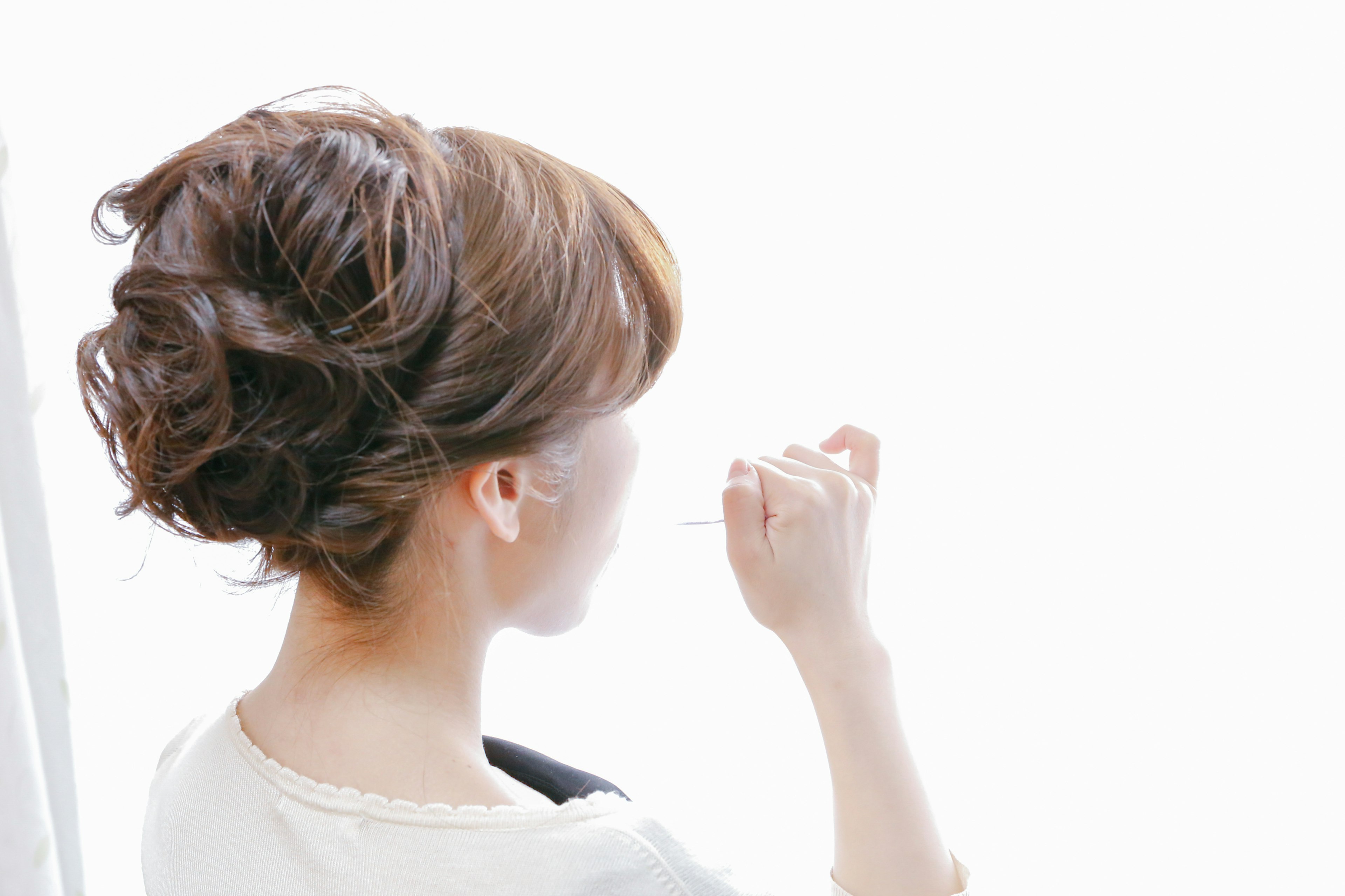 Mujer tocando su cabello con un fondo brillante