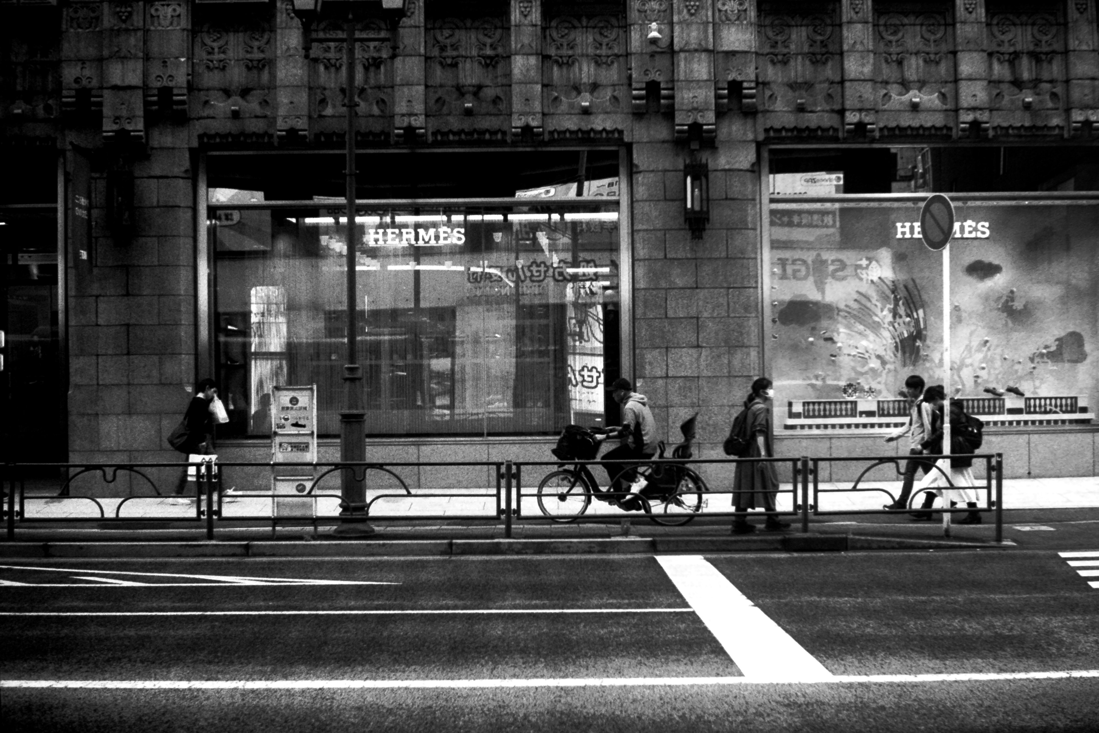 Black and white urban scene with pedestrians and cyclists