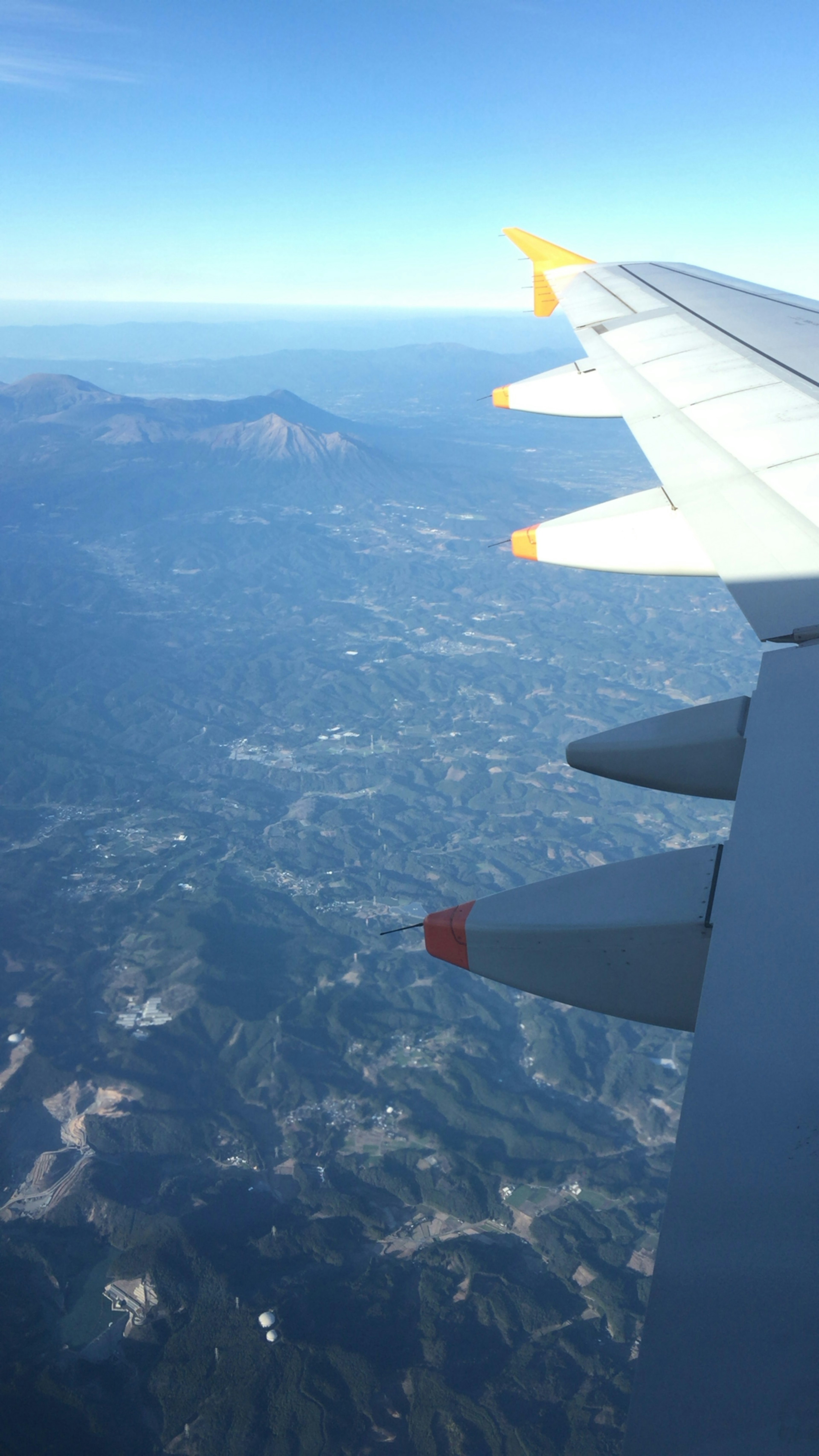 Vista panoramica di montagne da una finestra d'aereo con ala