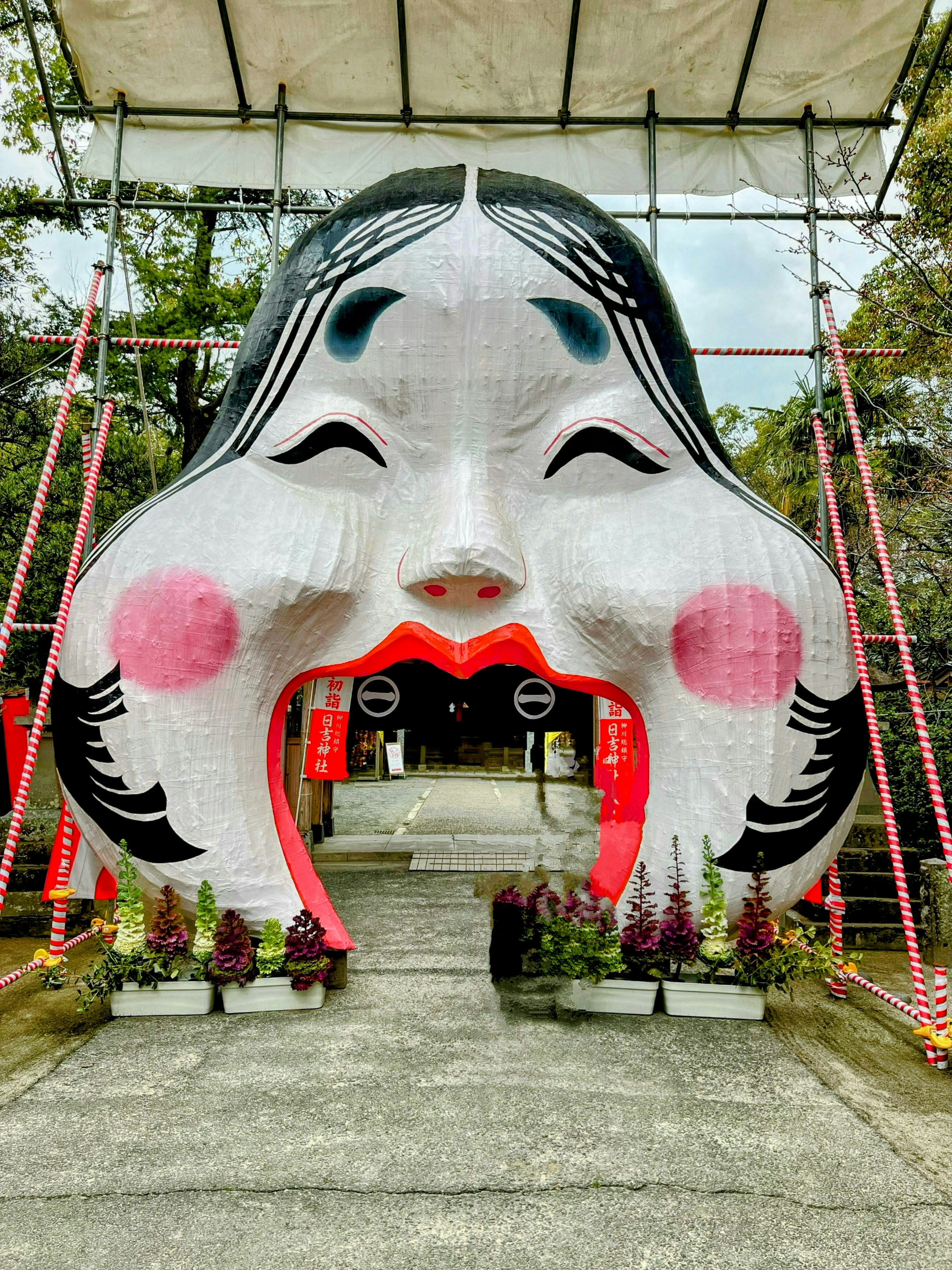 Large face-shaped arch entrance with distinctive red cheeks and eyes