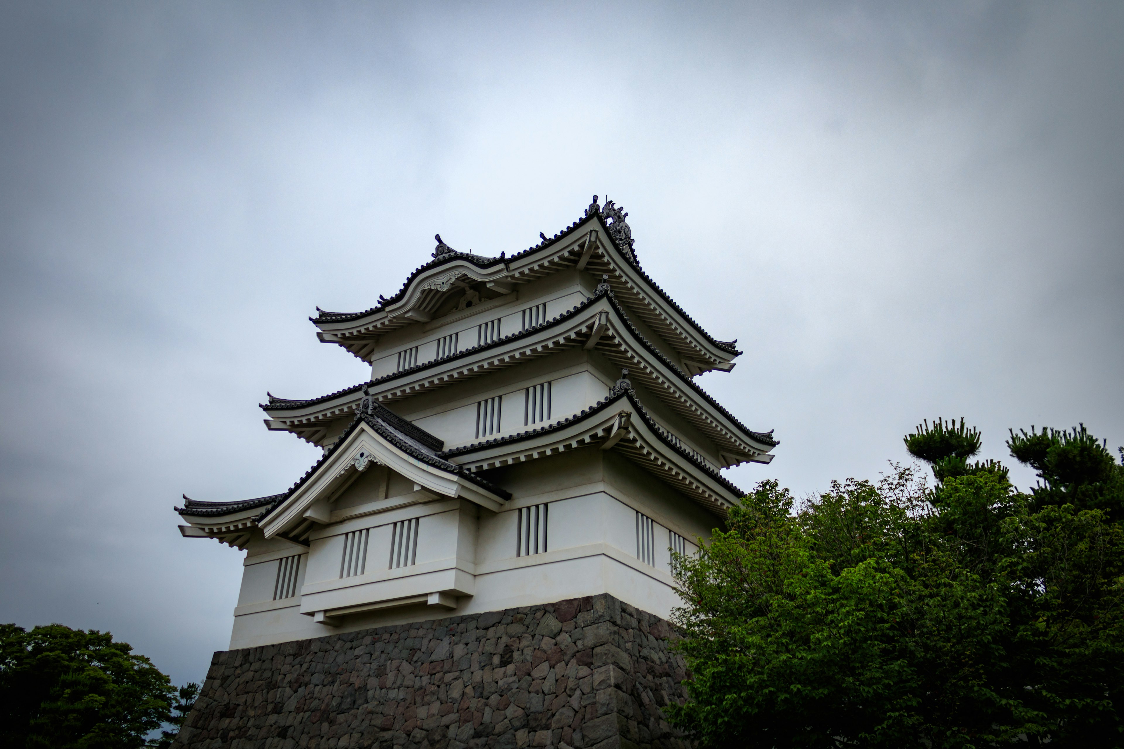 A beautiful Japanese castle structure surrounded by greenery