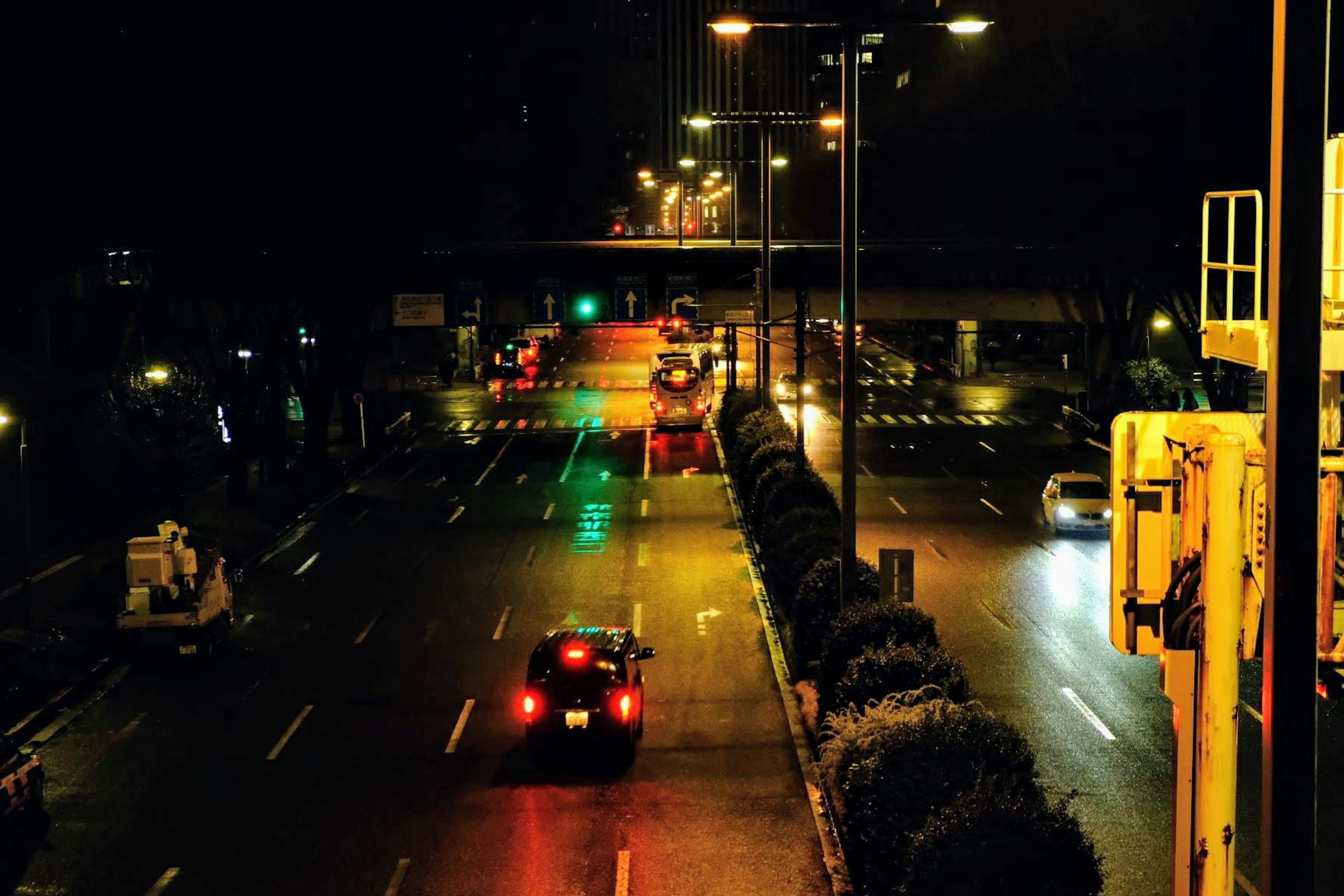 Vista notturna di una strada cittadina con veicoli e semafori