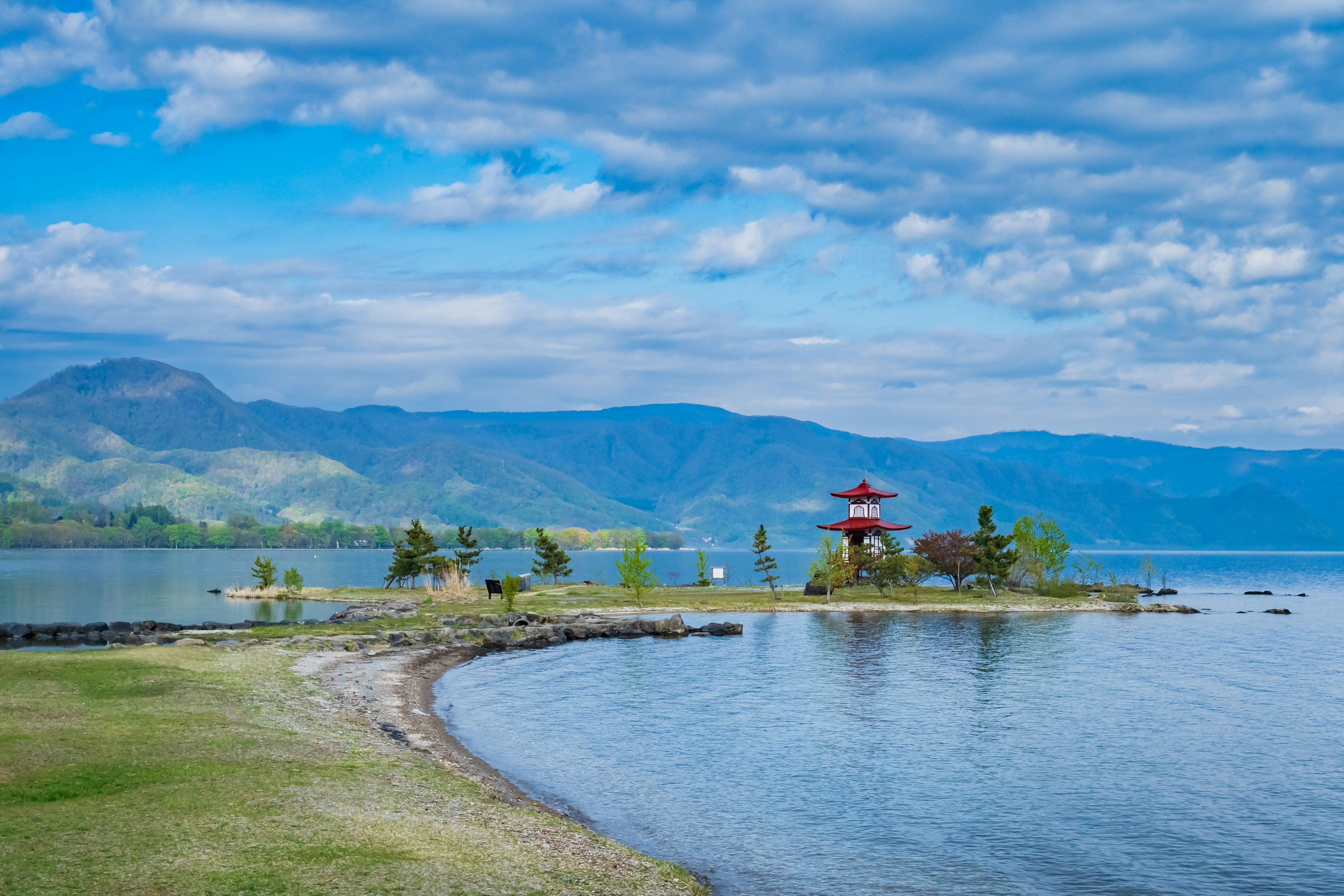 Scenic view of a blue lake with a red pavilion on an island