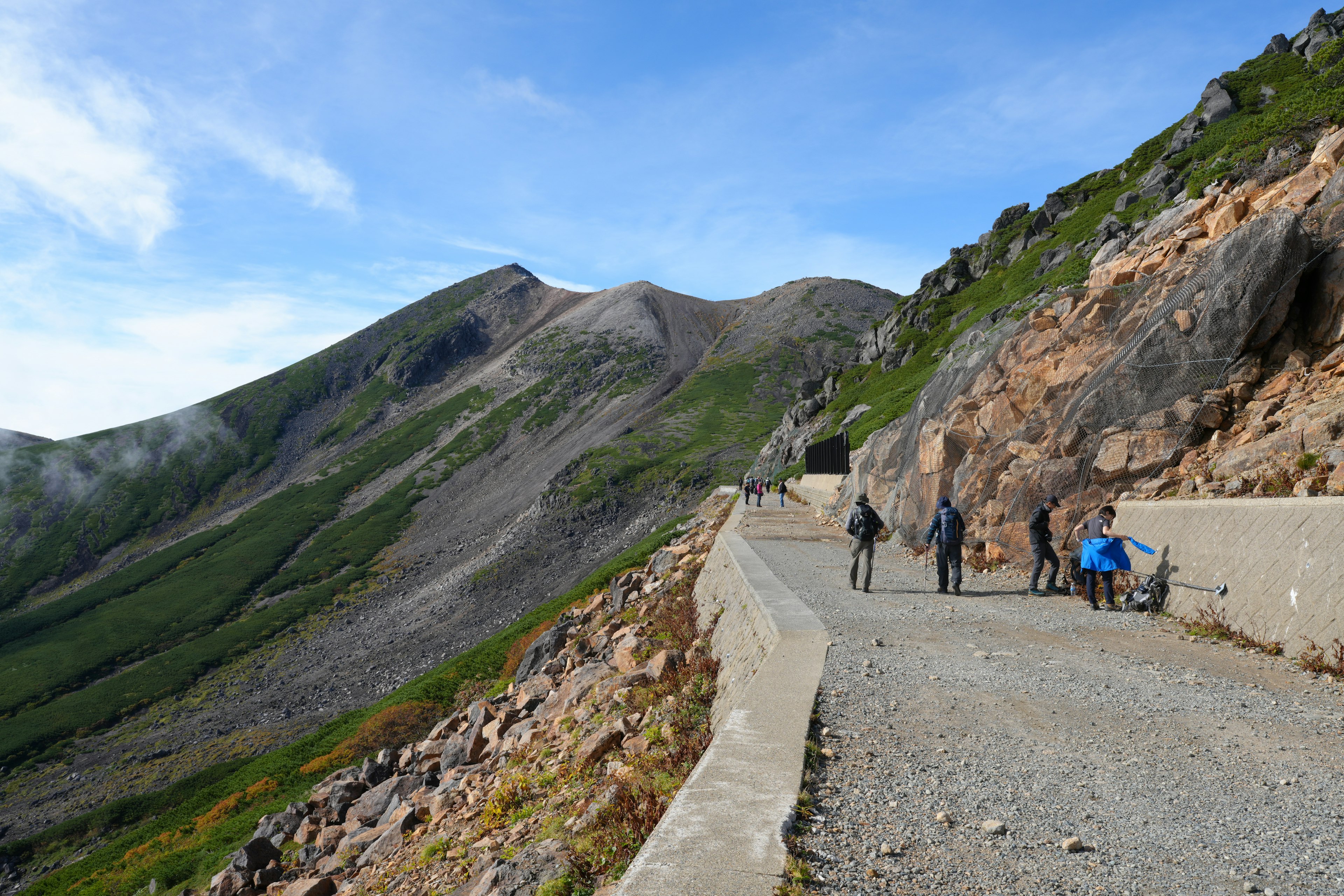 山の道を歩く人々と美しい風景