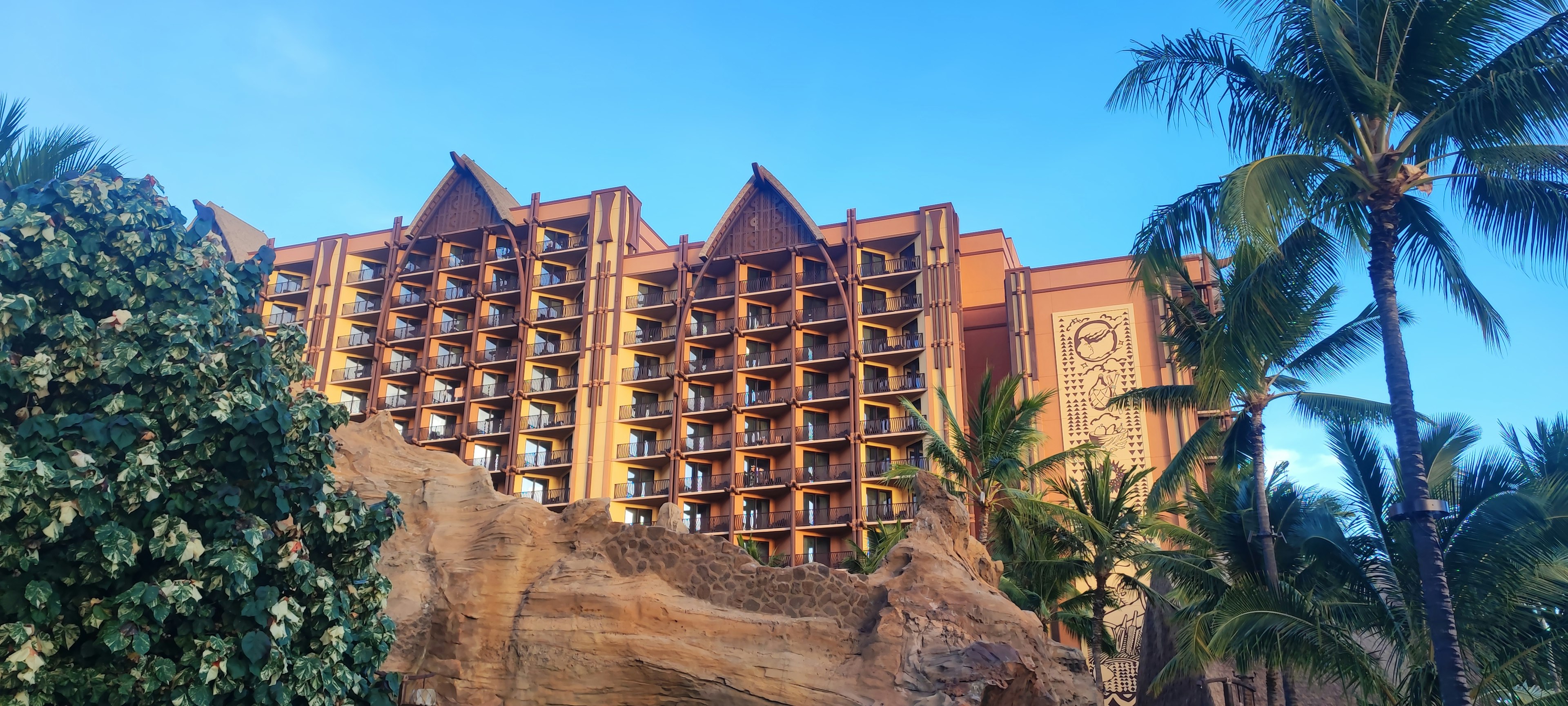 Außenansicht eines hawaiianischen Resorts mit blauem Himmel und Palmen, natürliche Landschaft