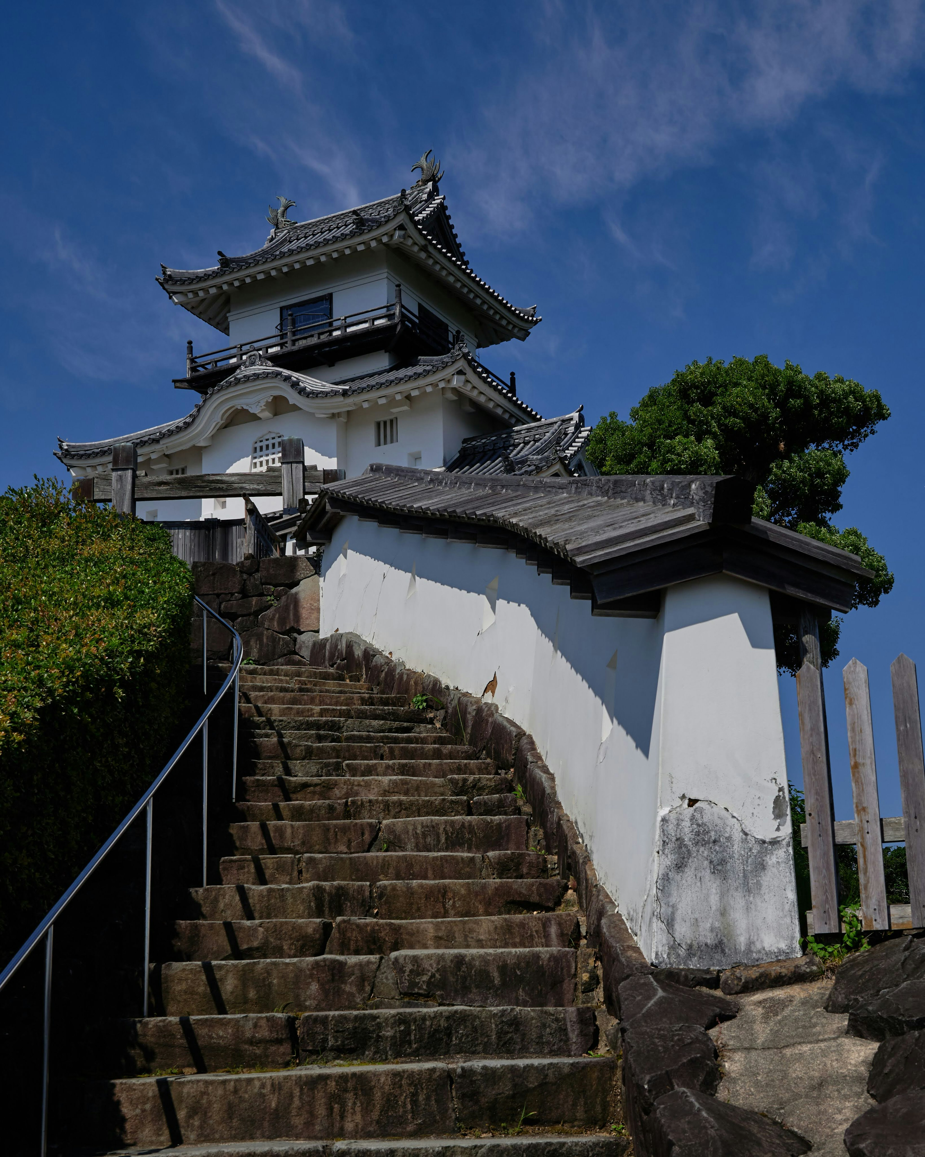 Château japonais traditionnel avec des marches en pierre et un ciel bleu