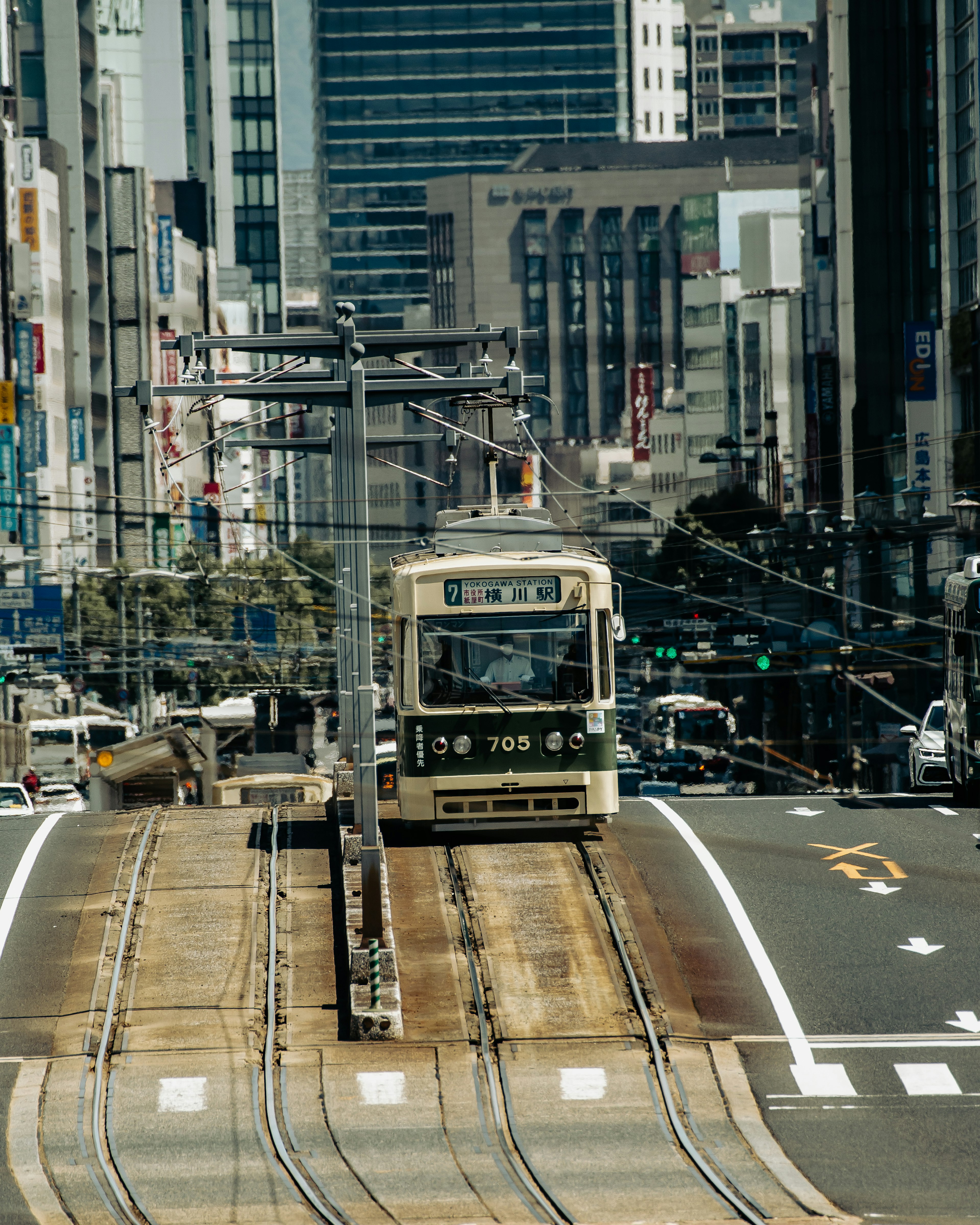 City tram on tracks surrounded by tall buildings