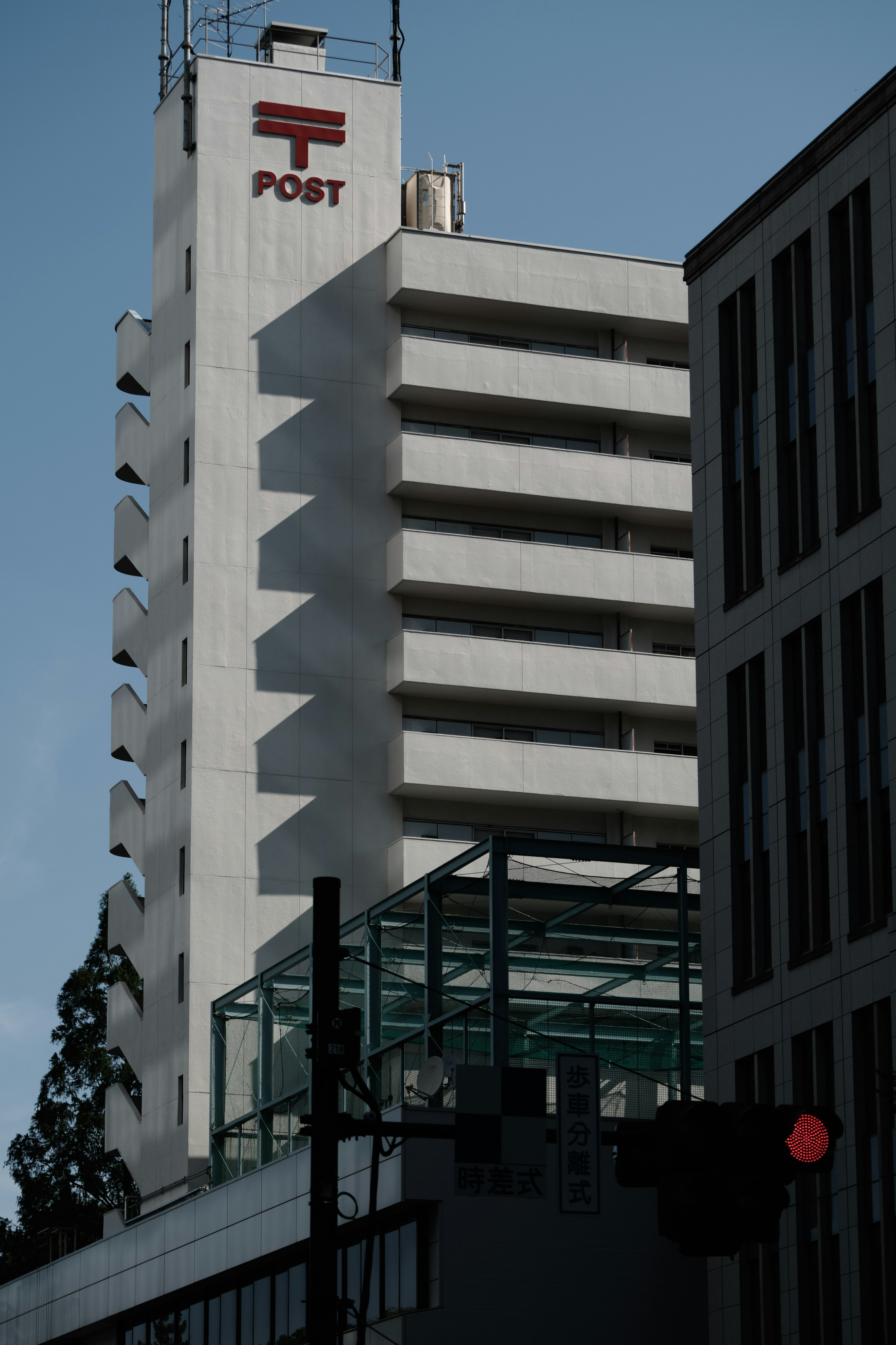 Extérieur d'un bâtiment postal blanc avec un feu rouge dans un cadre urbain