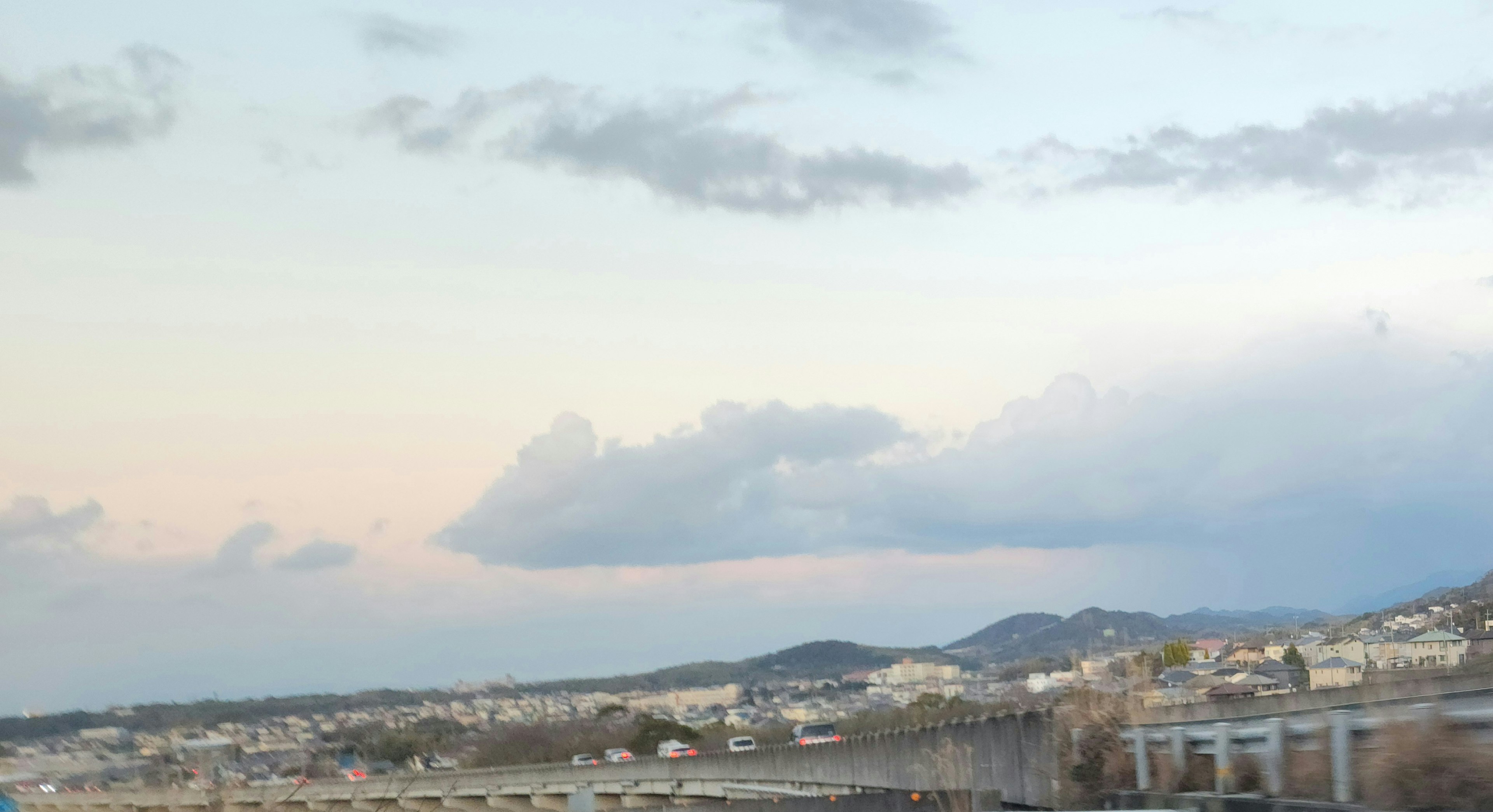 Paesaggio con cielo blu e nuvole con colline e una città