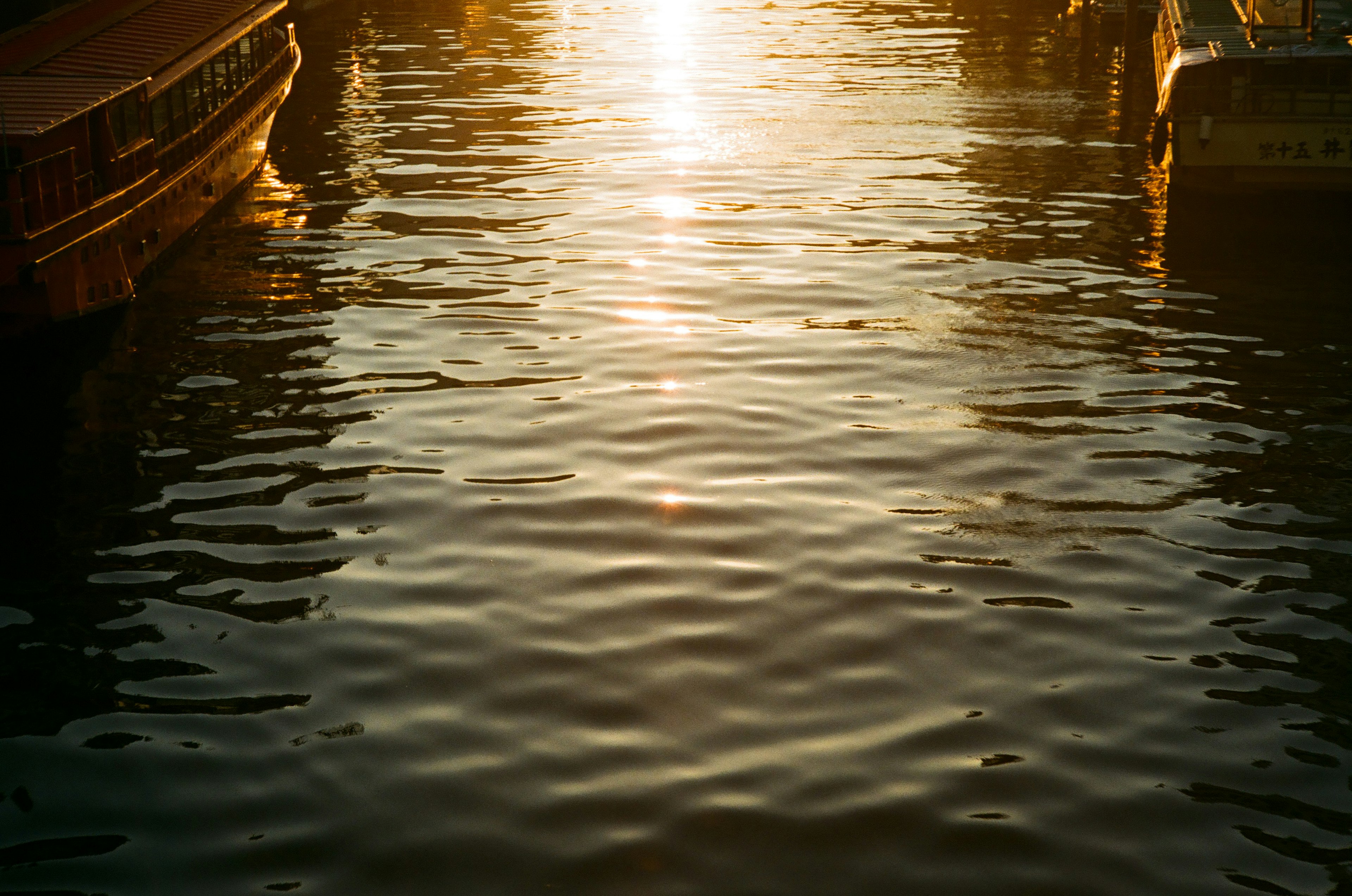 Sunset reflection on water with calm boats