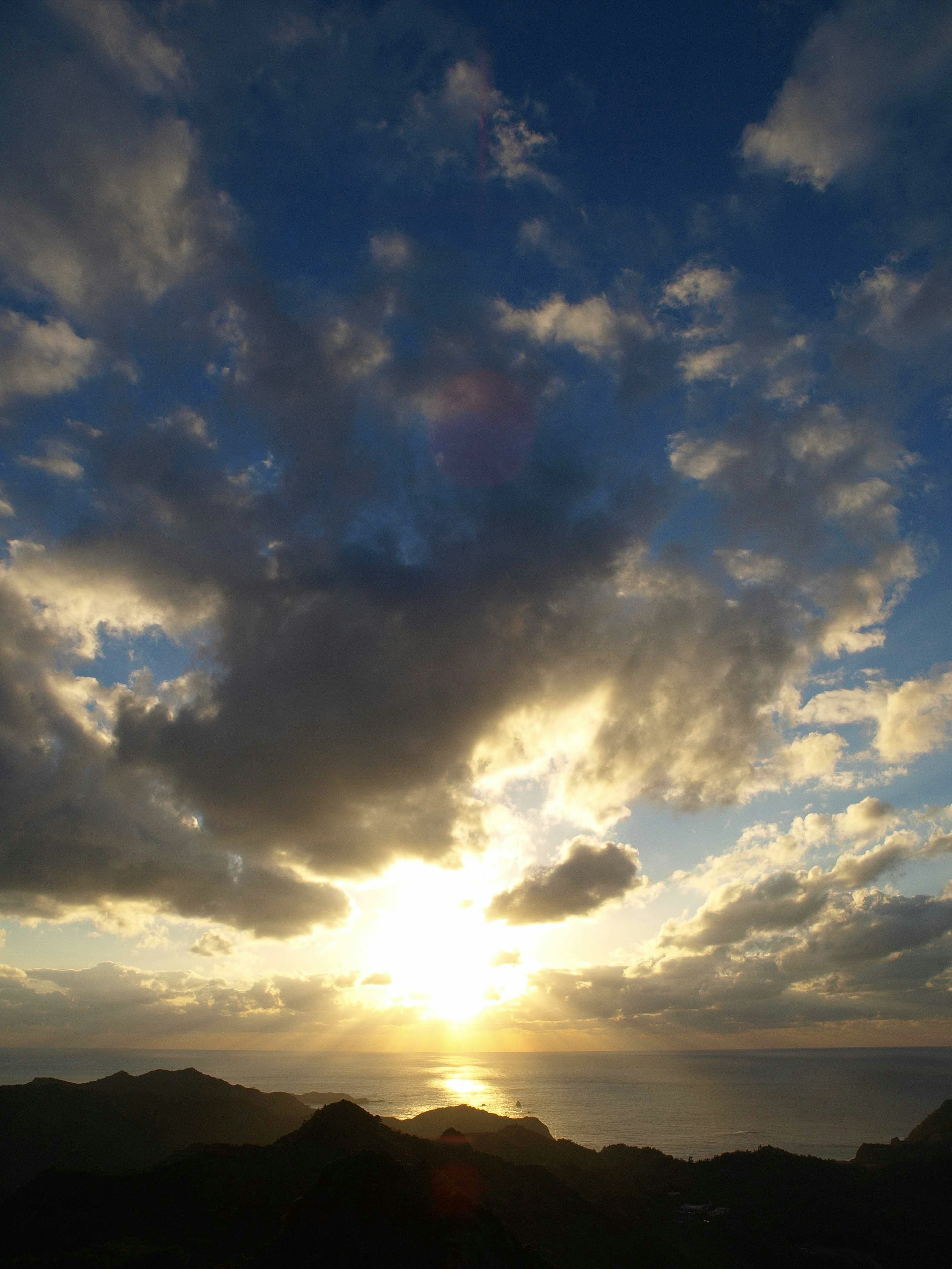 夕日が海に沈む美しい風景 様々な雲が空を彩る