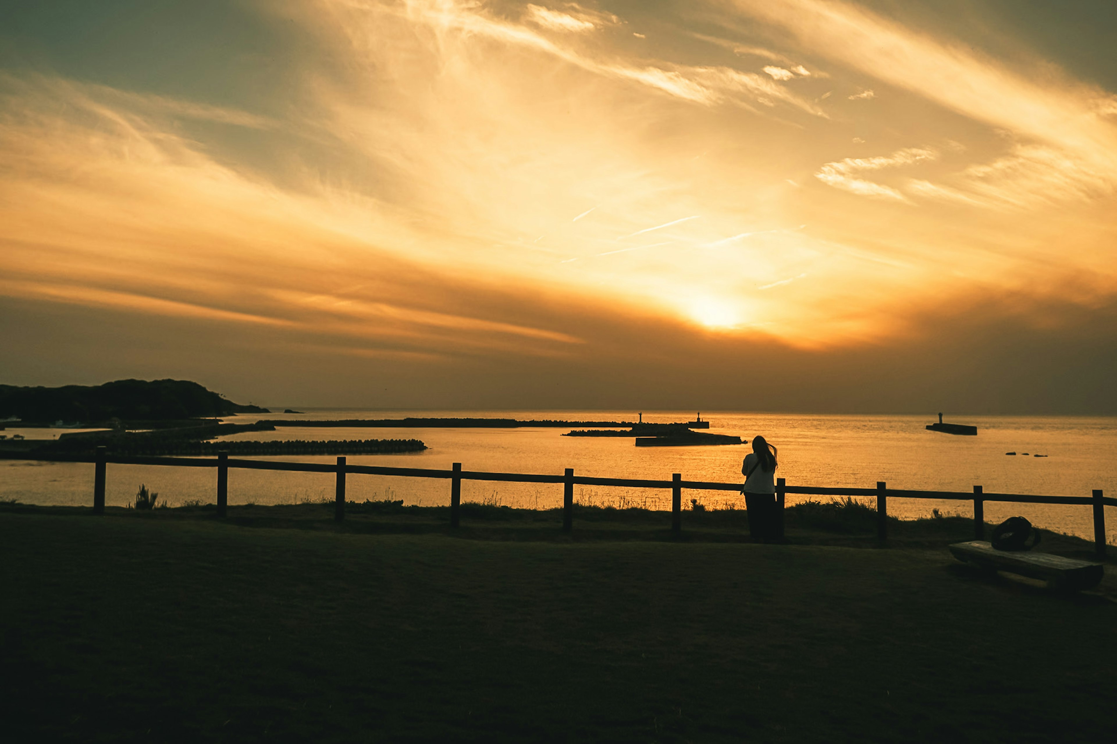 Paar steht am Meer bei Sonnenuntergang Wunderschöner Himmel mit Sonnenuntergangsfarben und ruhigem Wasser