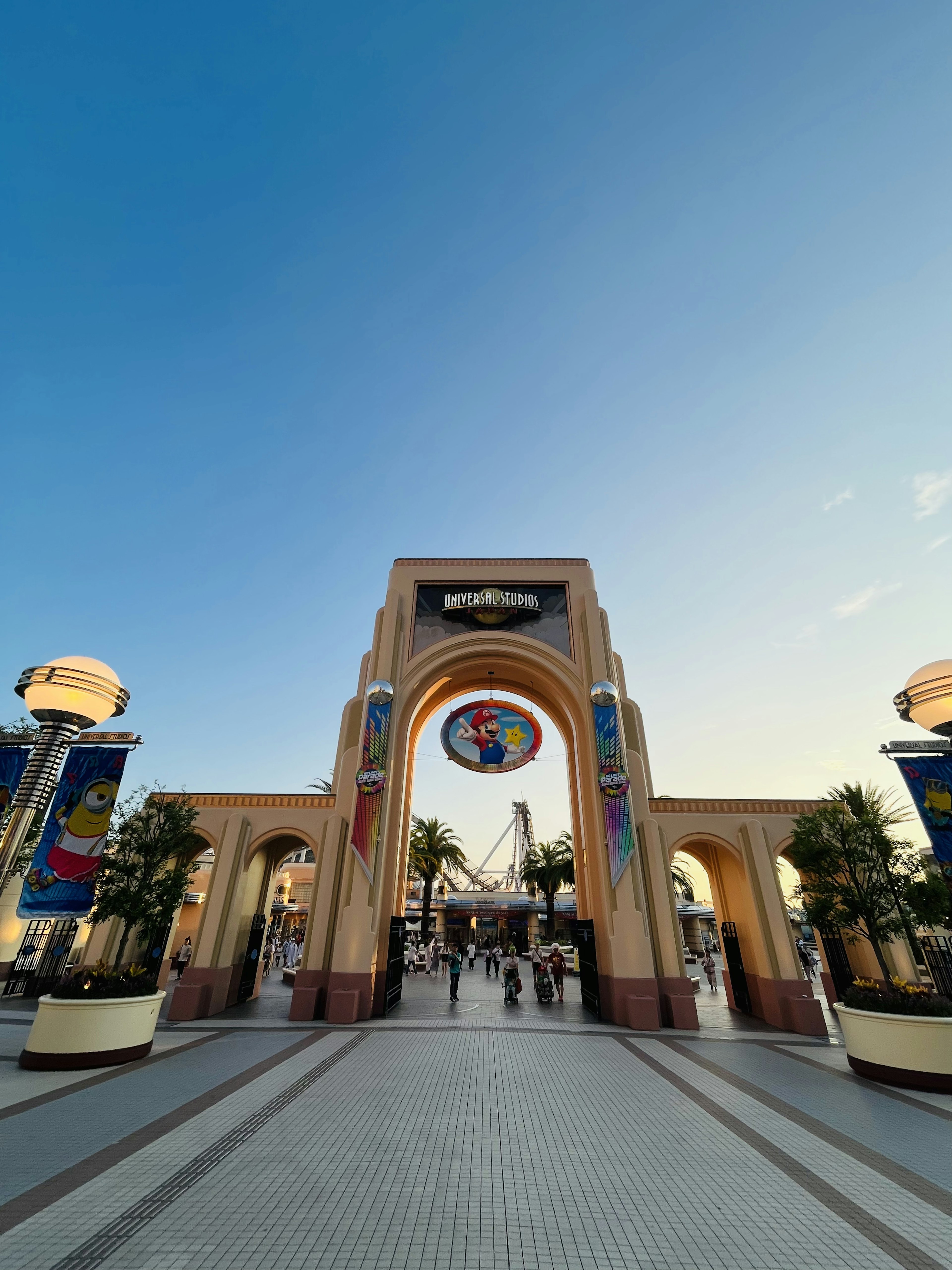 Entrance archway of an amusement park with a colorful sign and clear blue sky