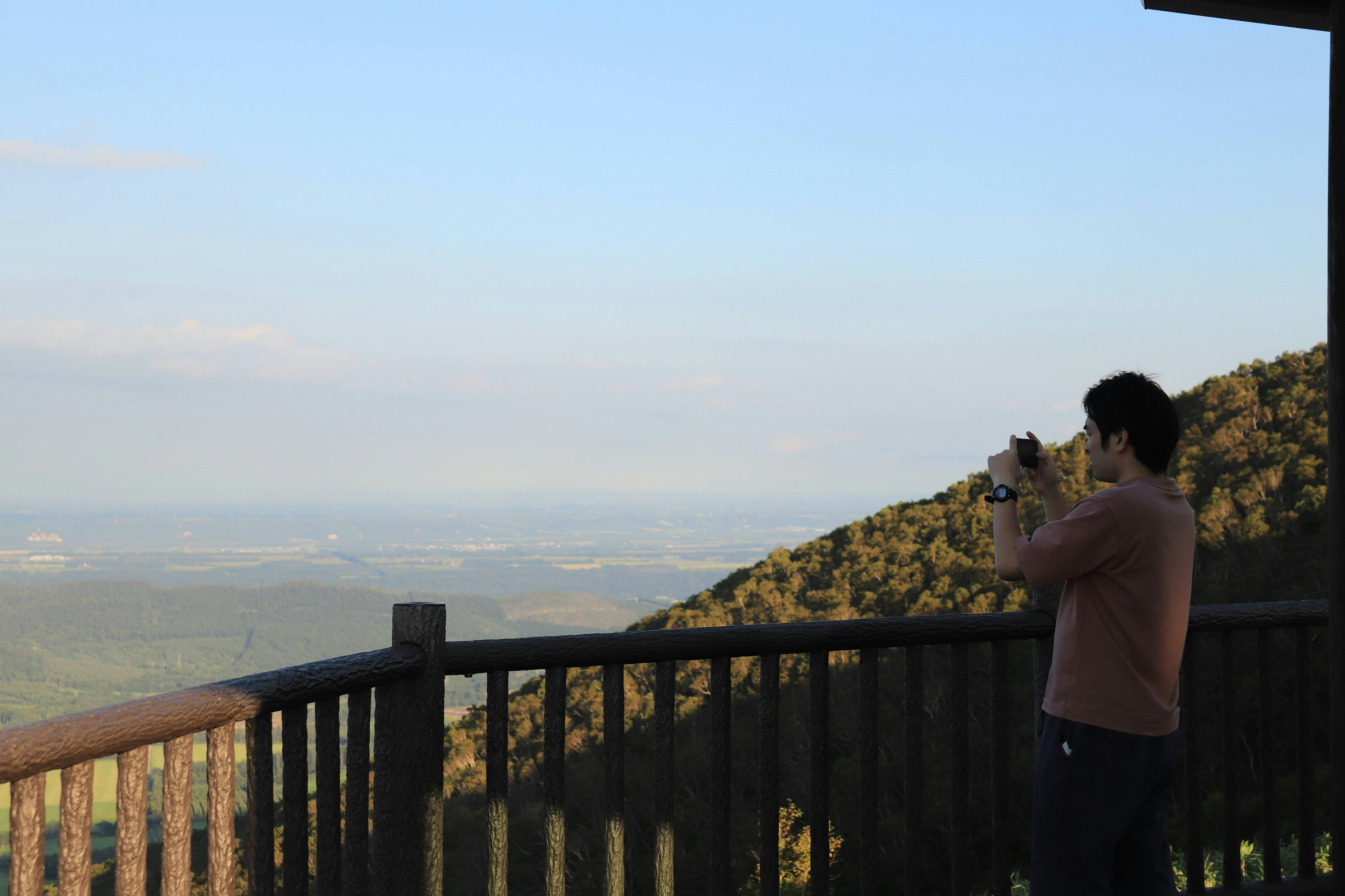 Persona che scatta una foto da un punto panoramico su un paesaggio montano