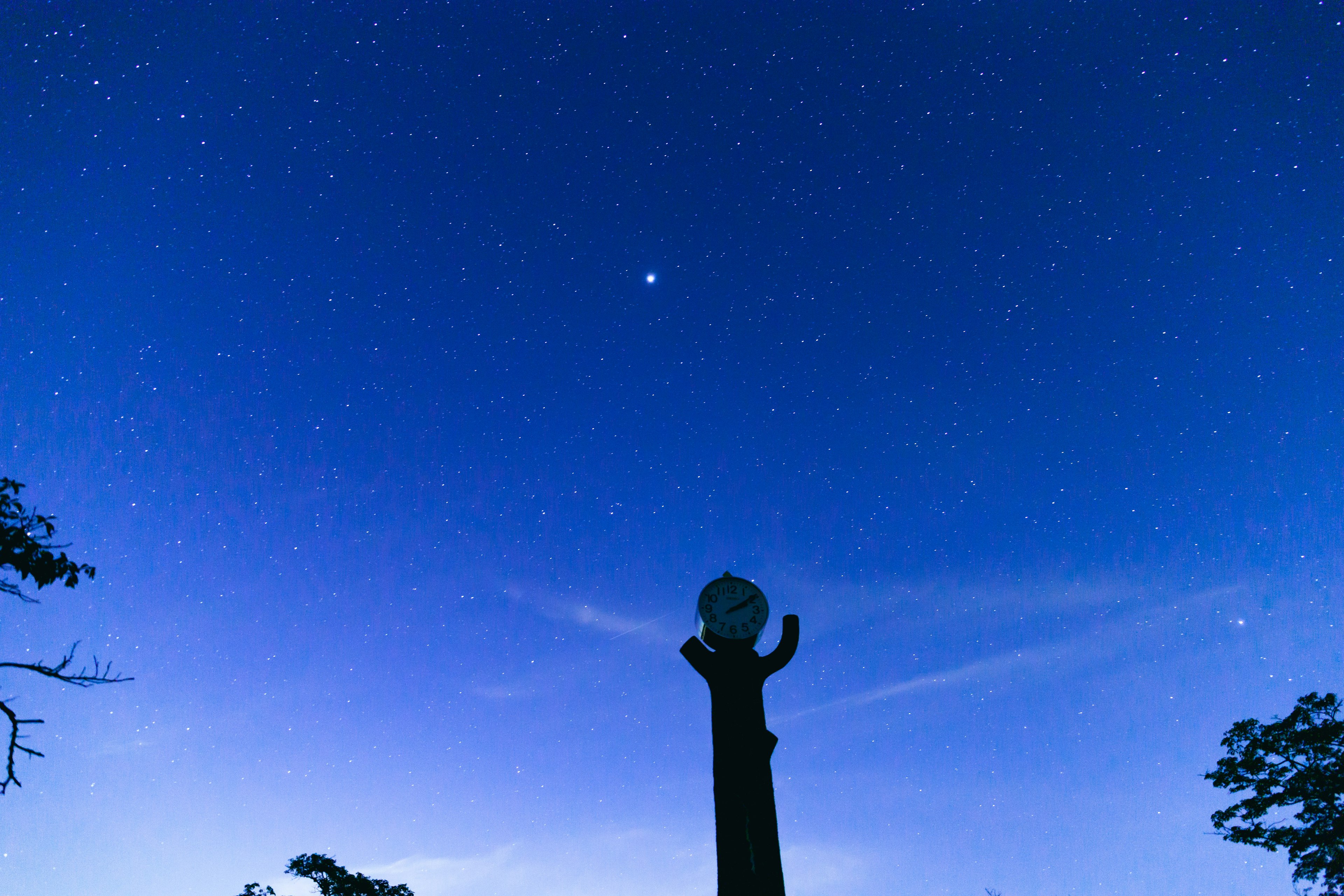 Langit malam penuh bintang dan siluet patung