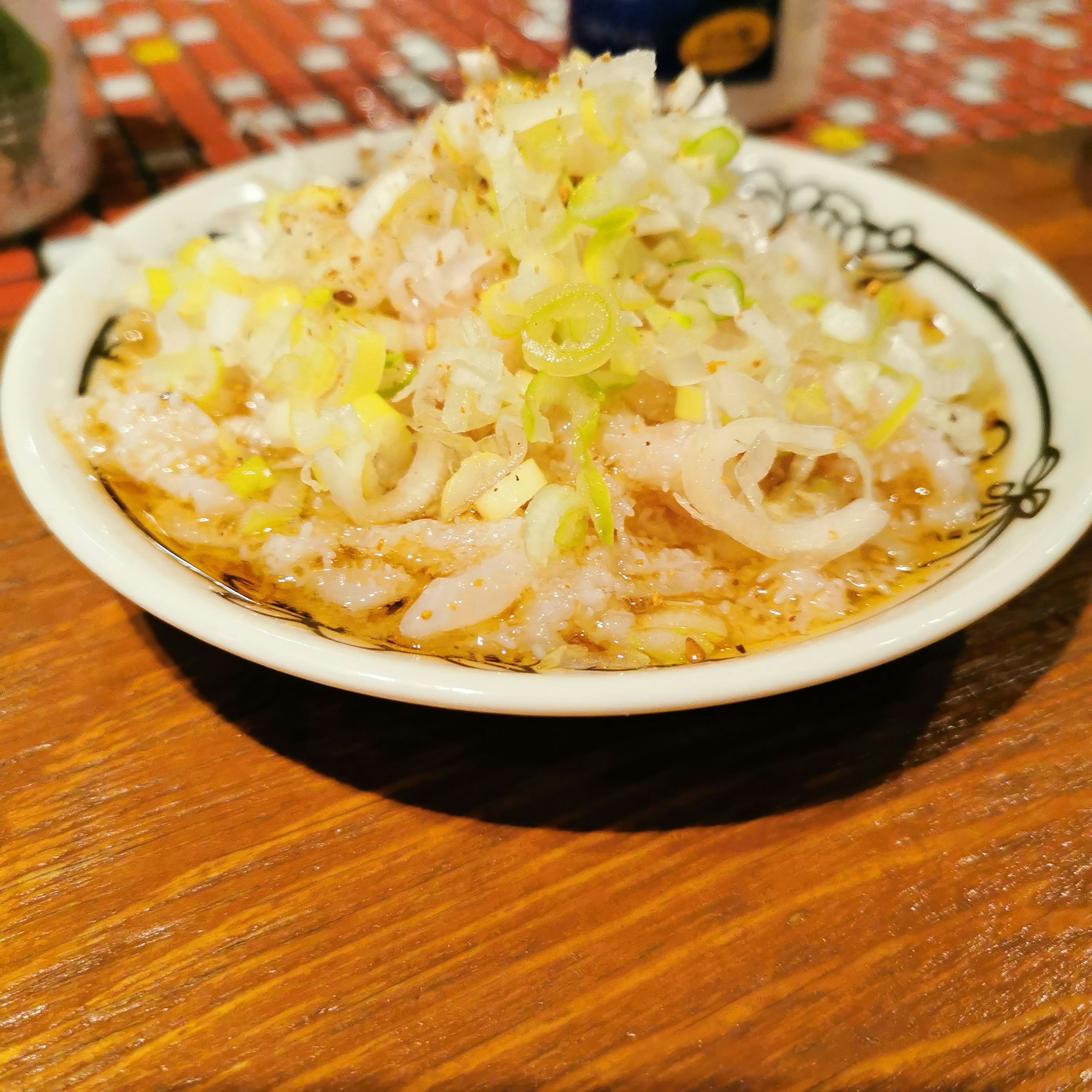 Dish in a white bowl topped with finely chopped green onions