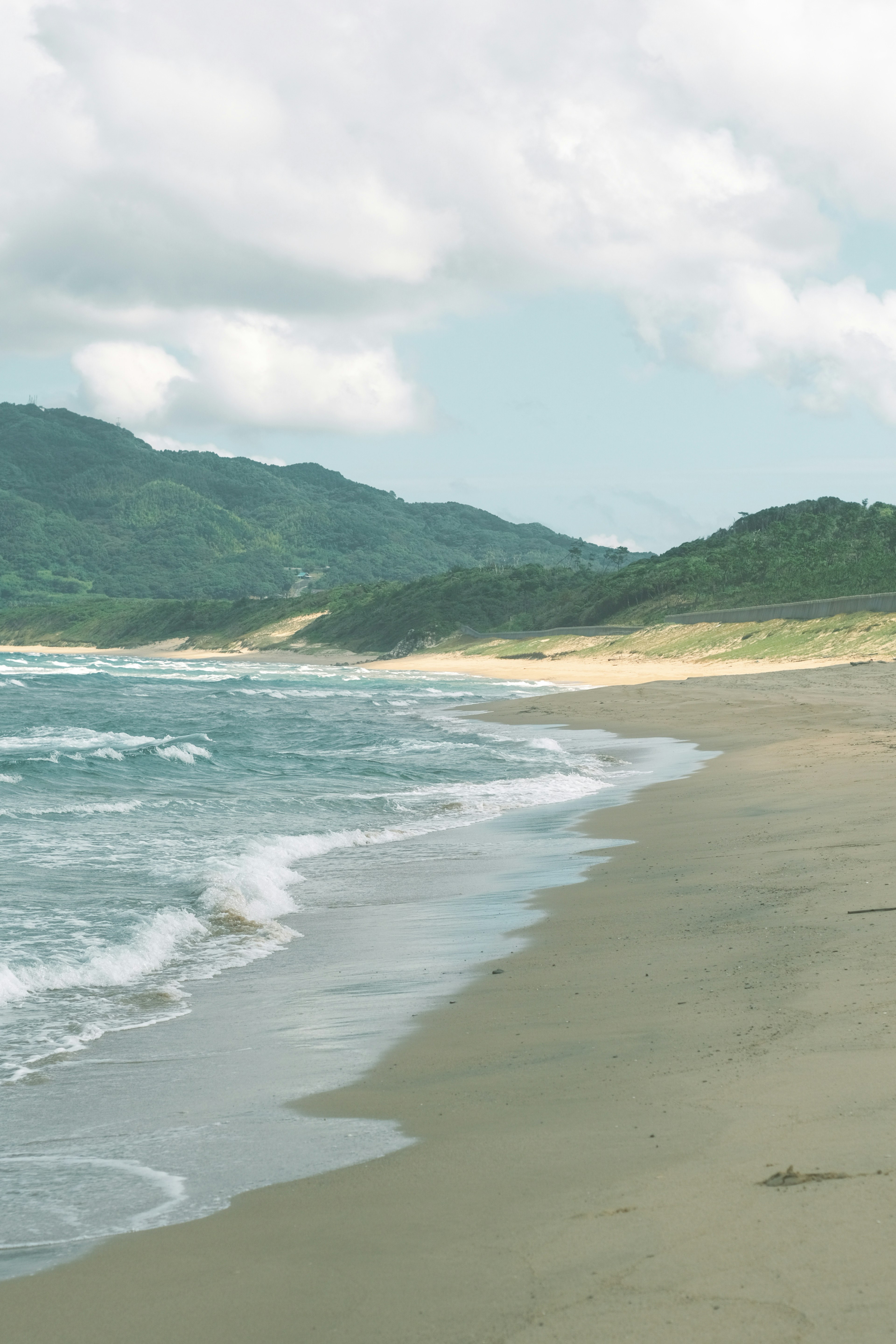 穏やかな海岸線と波が寄せるビーチの風景