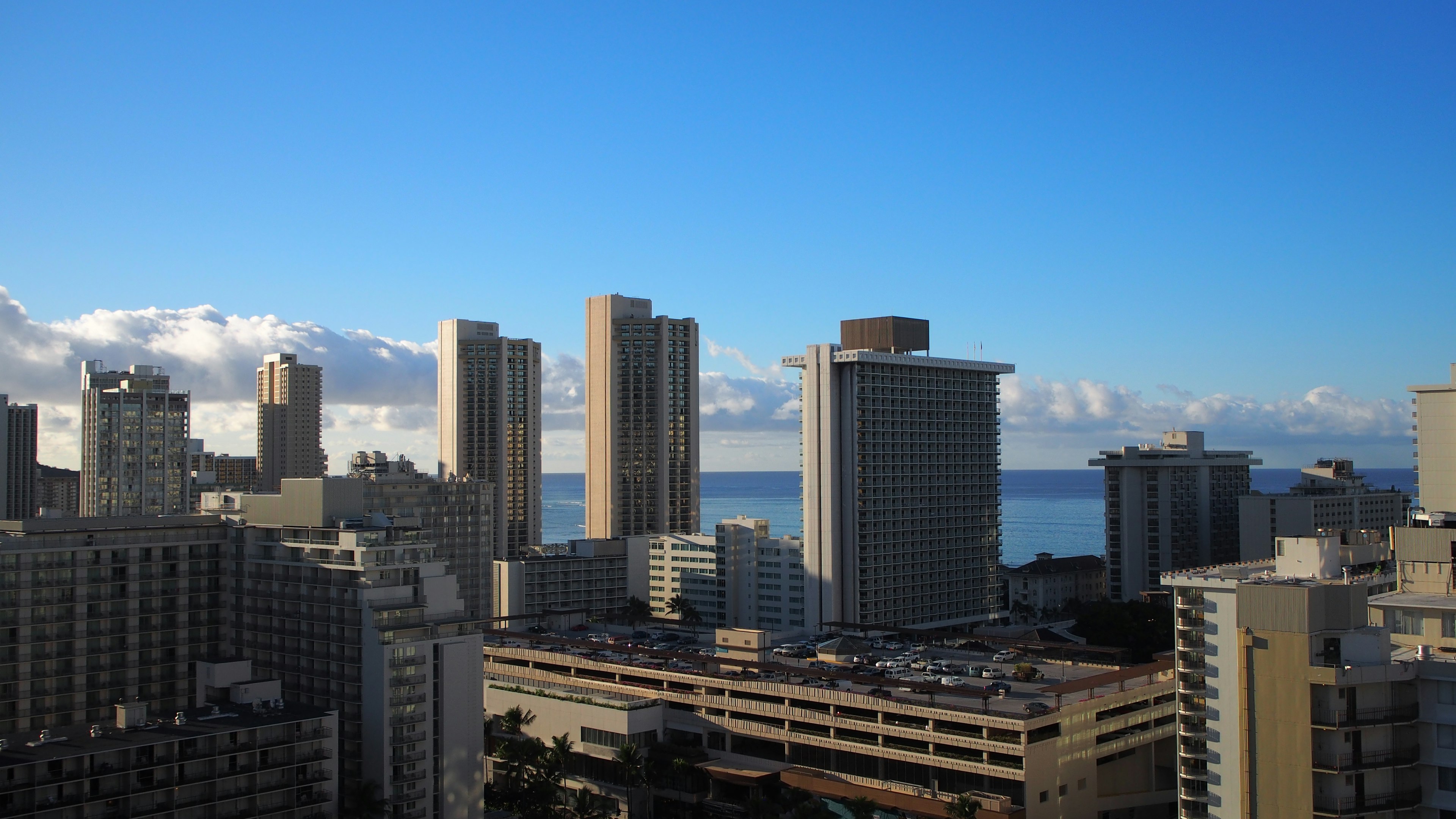 Skyline urbana con grattacieli e vista sull'oceano sotto un cielo blu