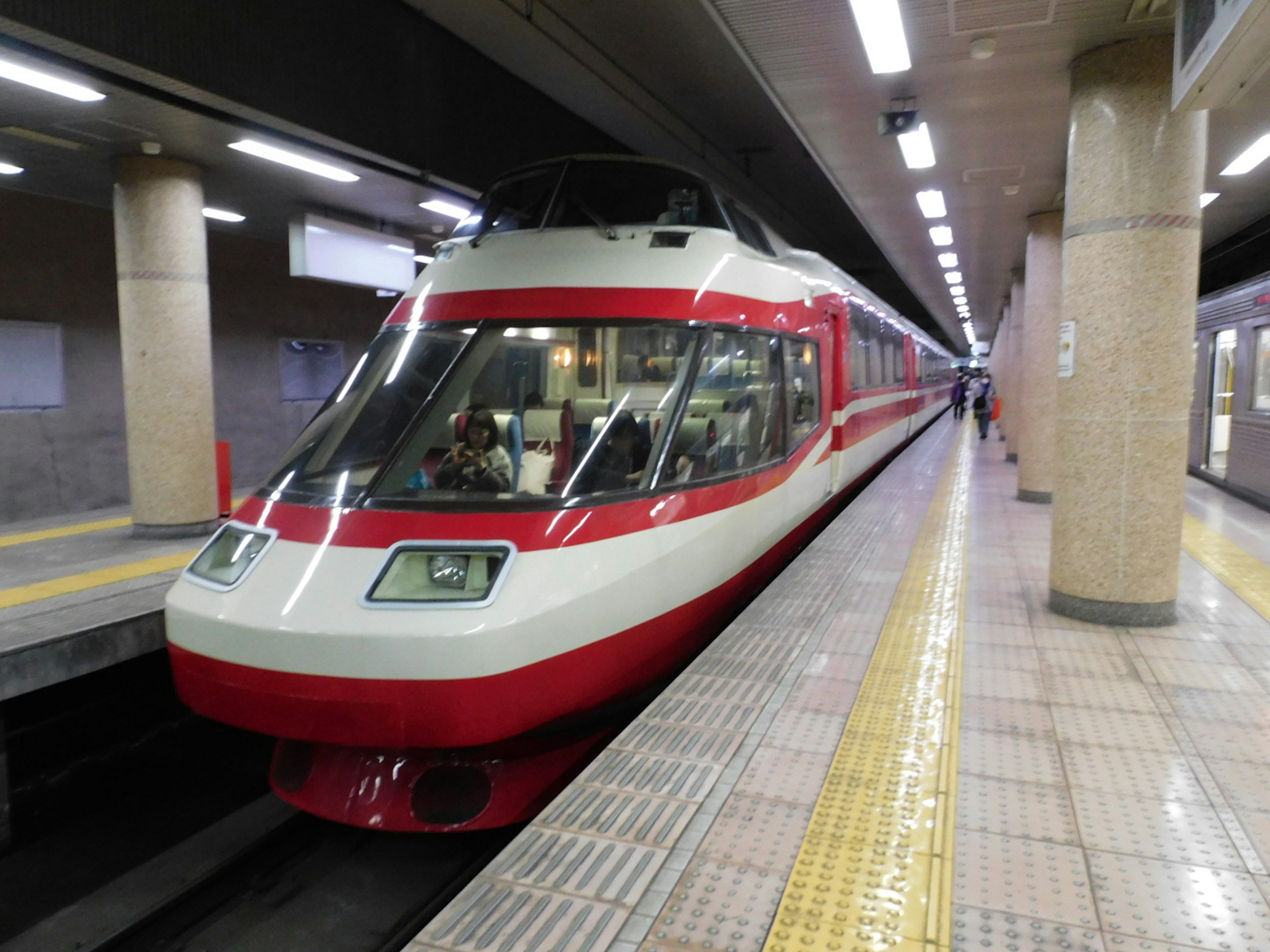 A red and white train is stopped at a station