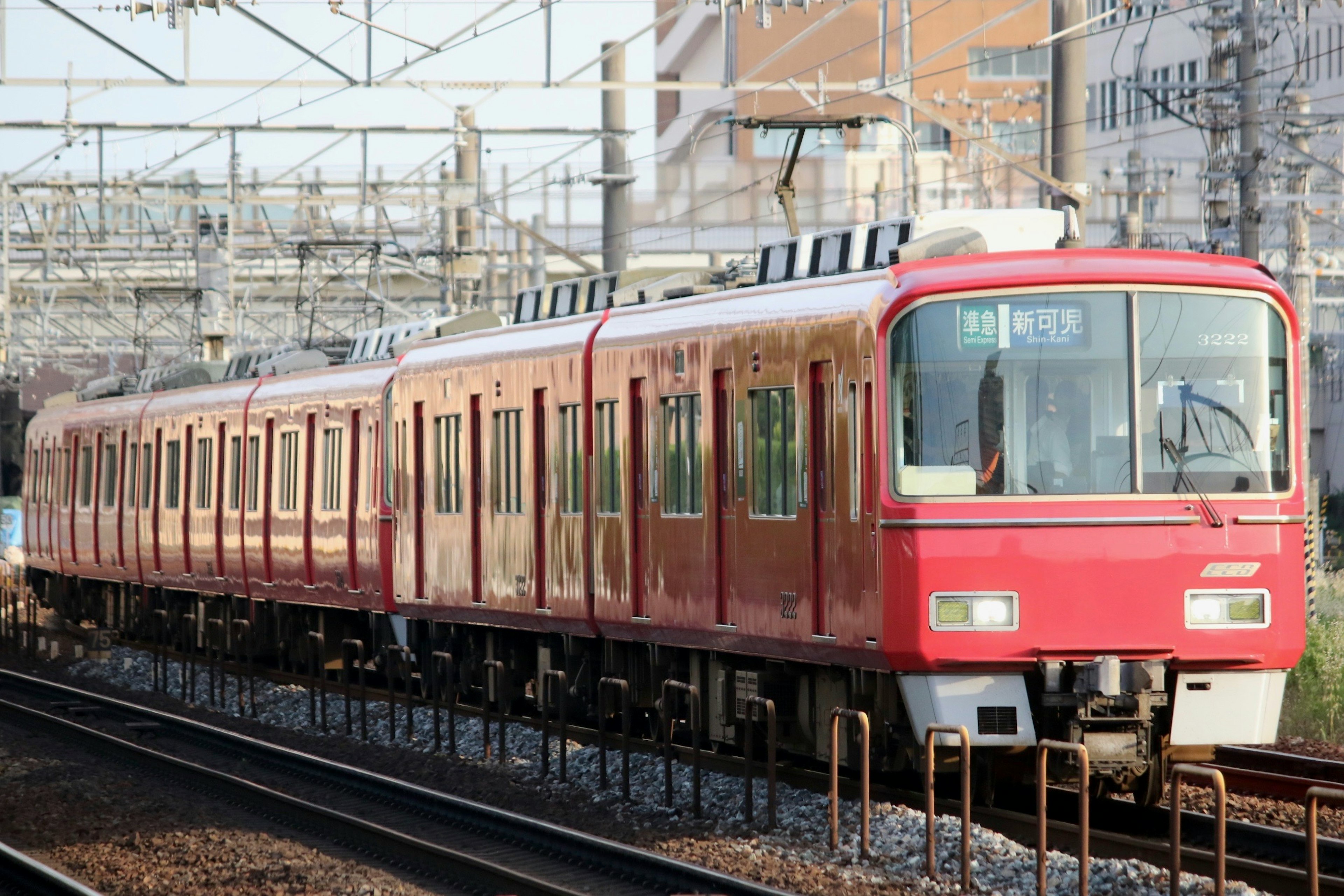 รถไฟสีแดงวิ่งบนรางพร้อมพื้นหลังเมือง