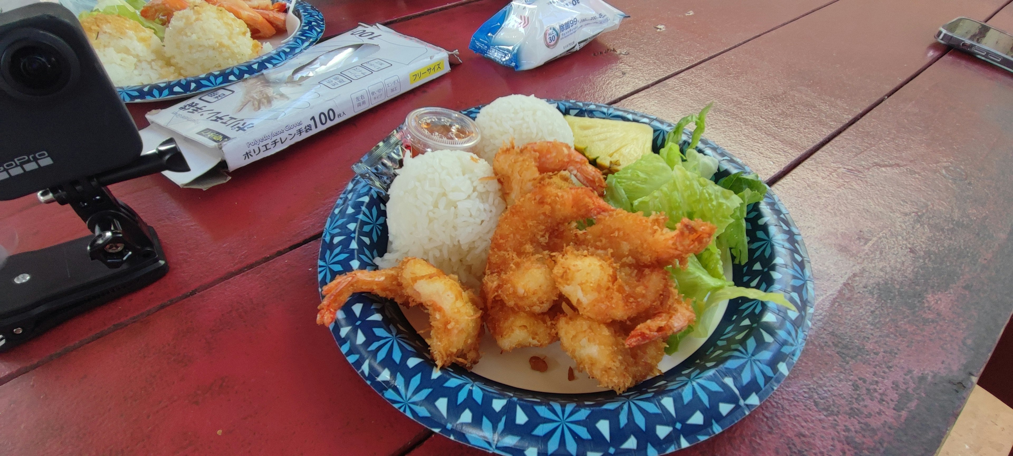 Fried shrimp served on a blue plate with rice and salad