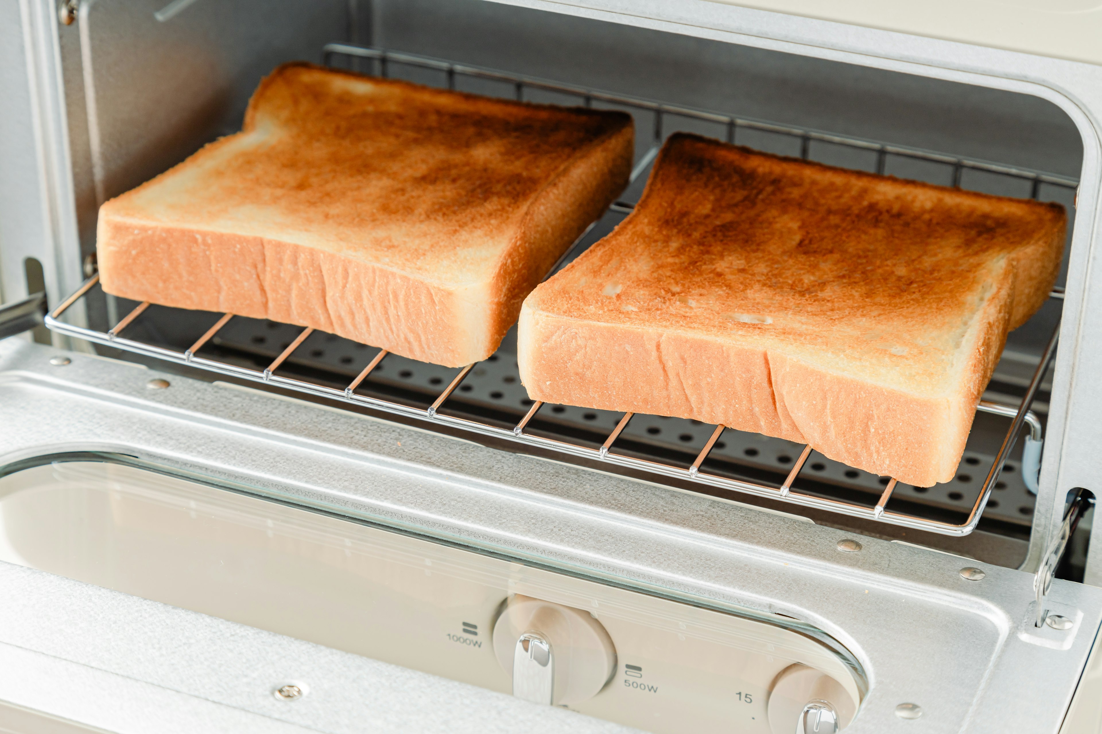 Two slices of toasted bread inside a toaster