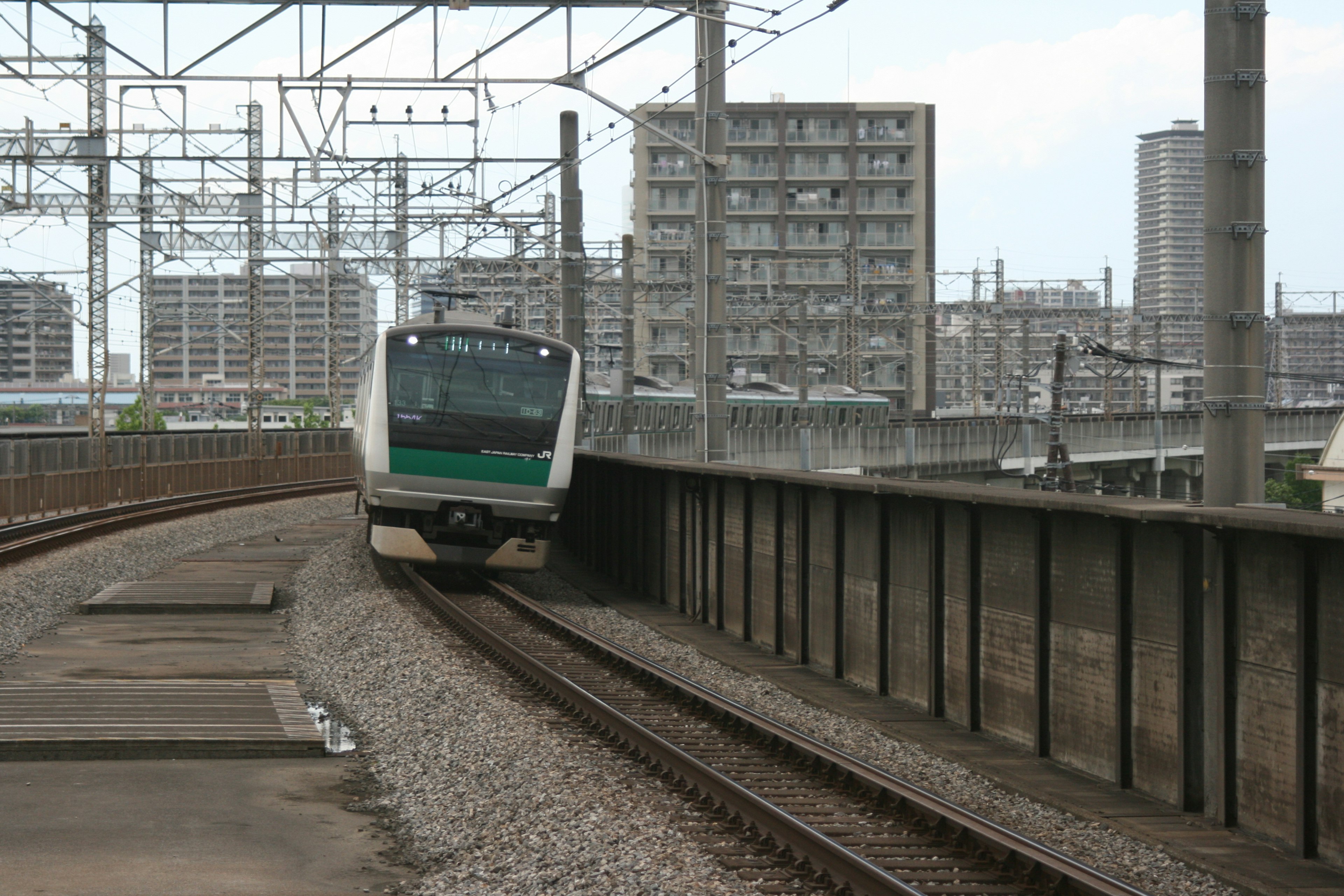 Treno che percorre un binario curvo con edifici circostanti