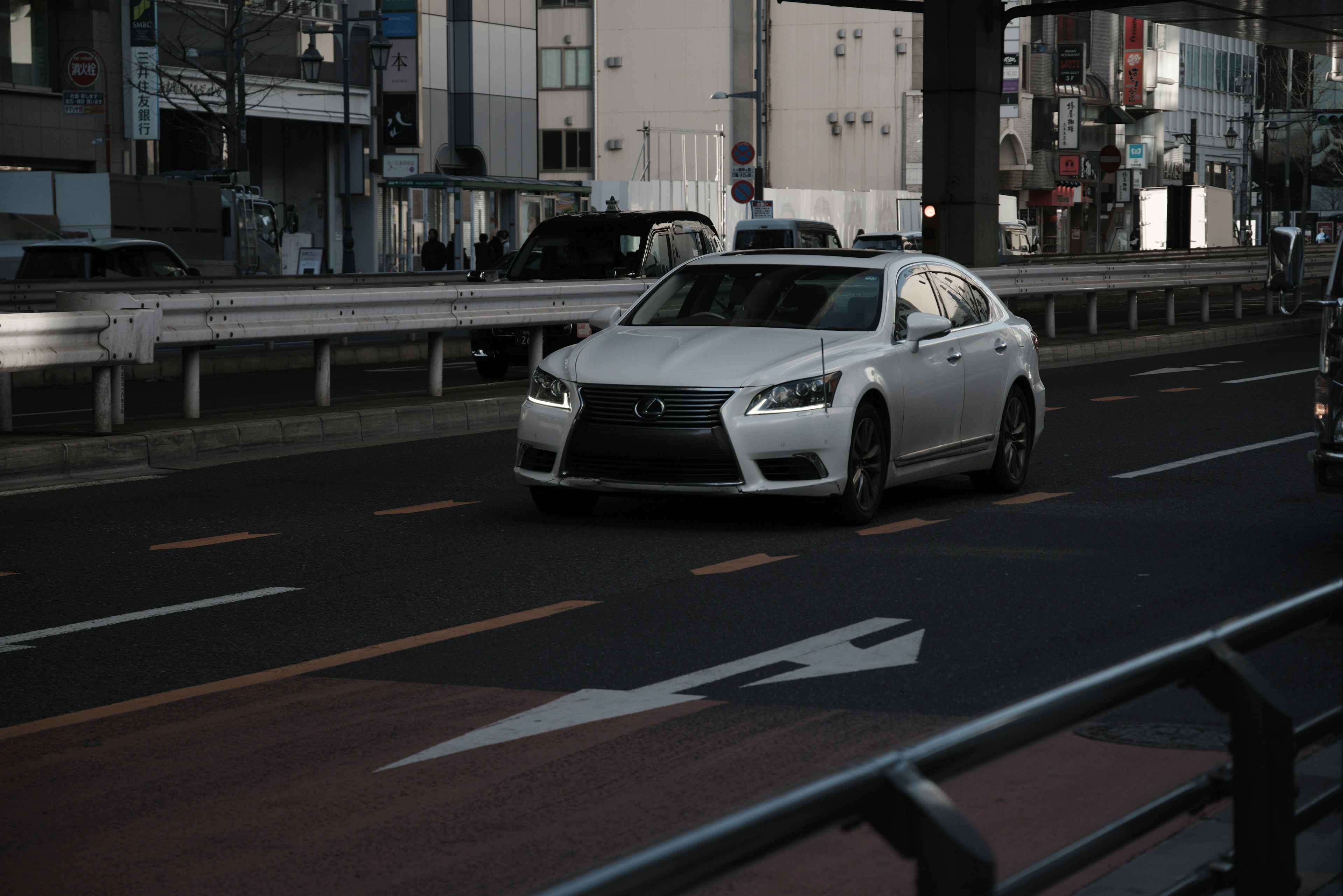 Ein weißes Luxusauto fährt auf einer Stadtstraße