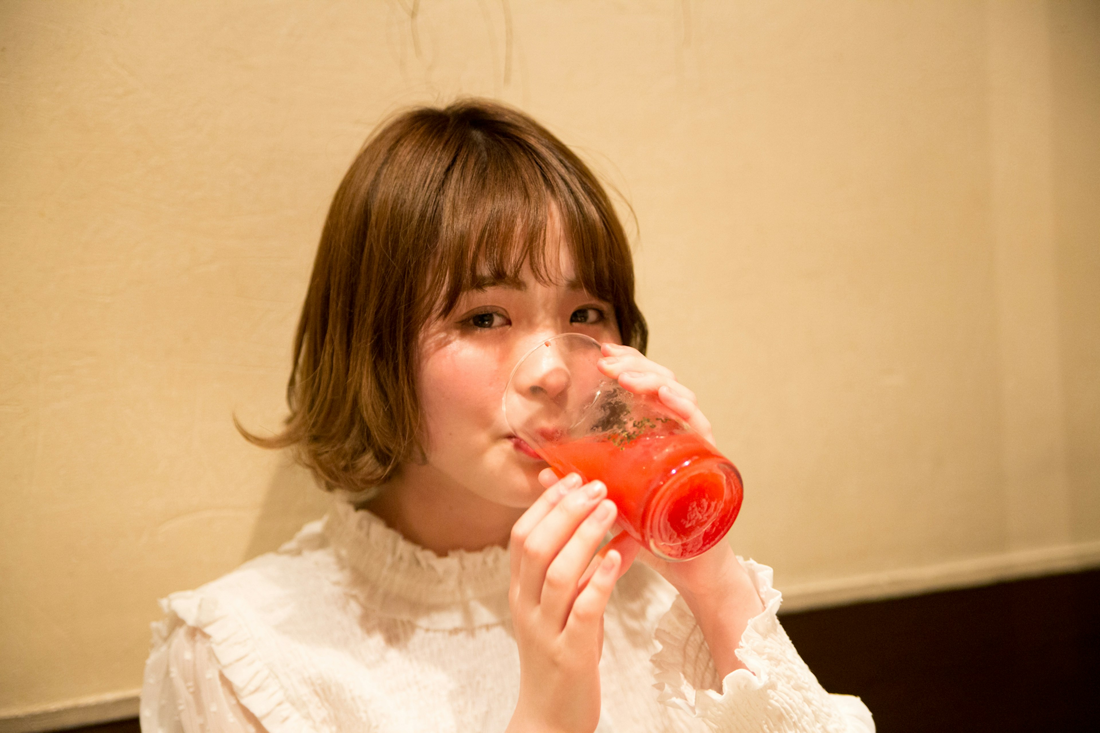 Une femme sirotant une boisson rouge dans une atmosphère romantique