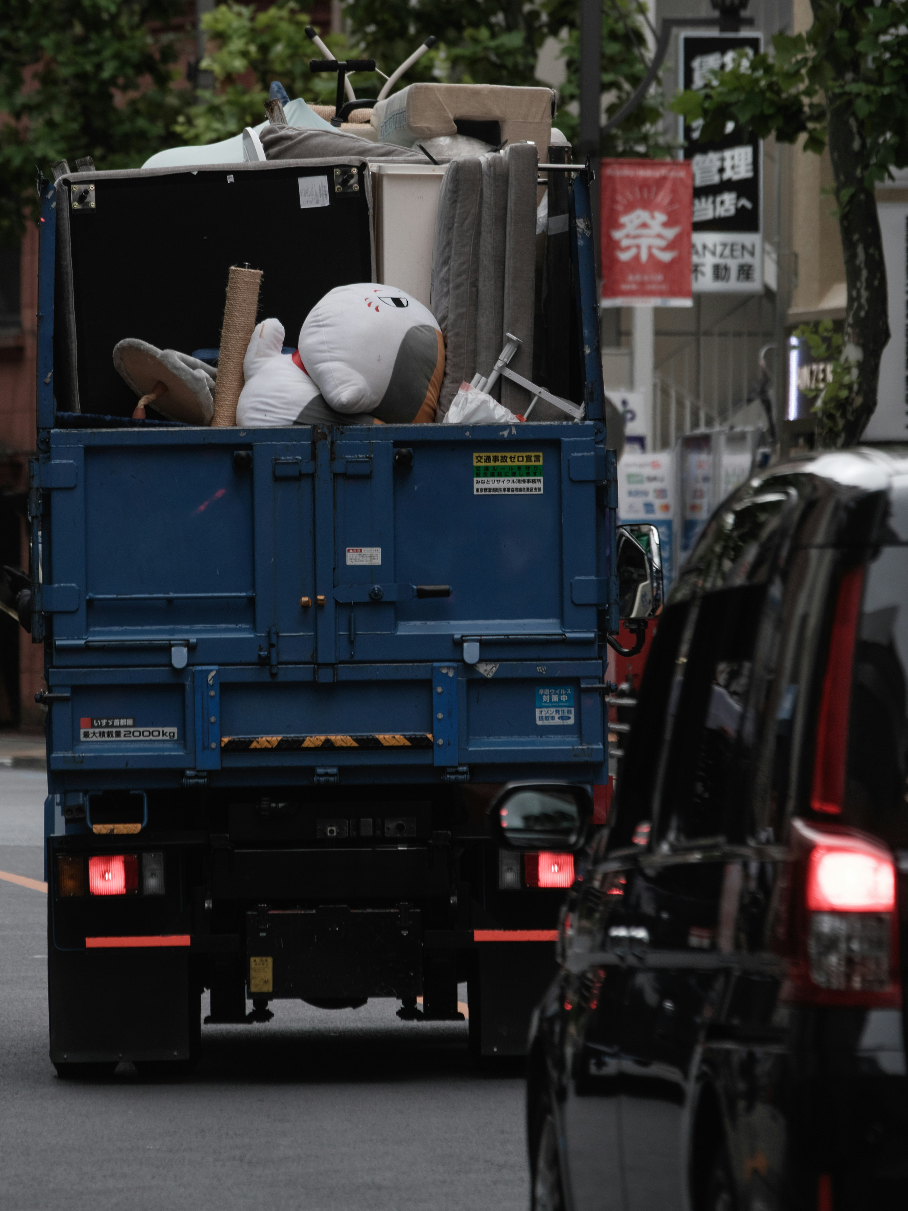 Blue truck filled with discarded items on the street