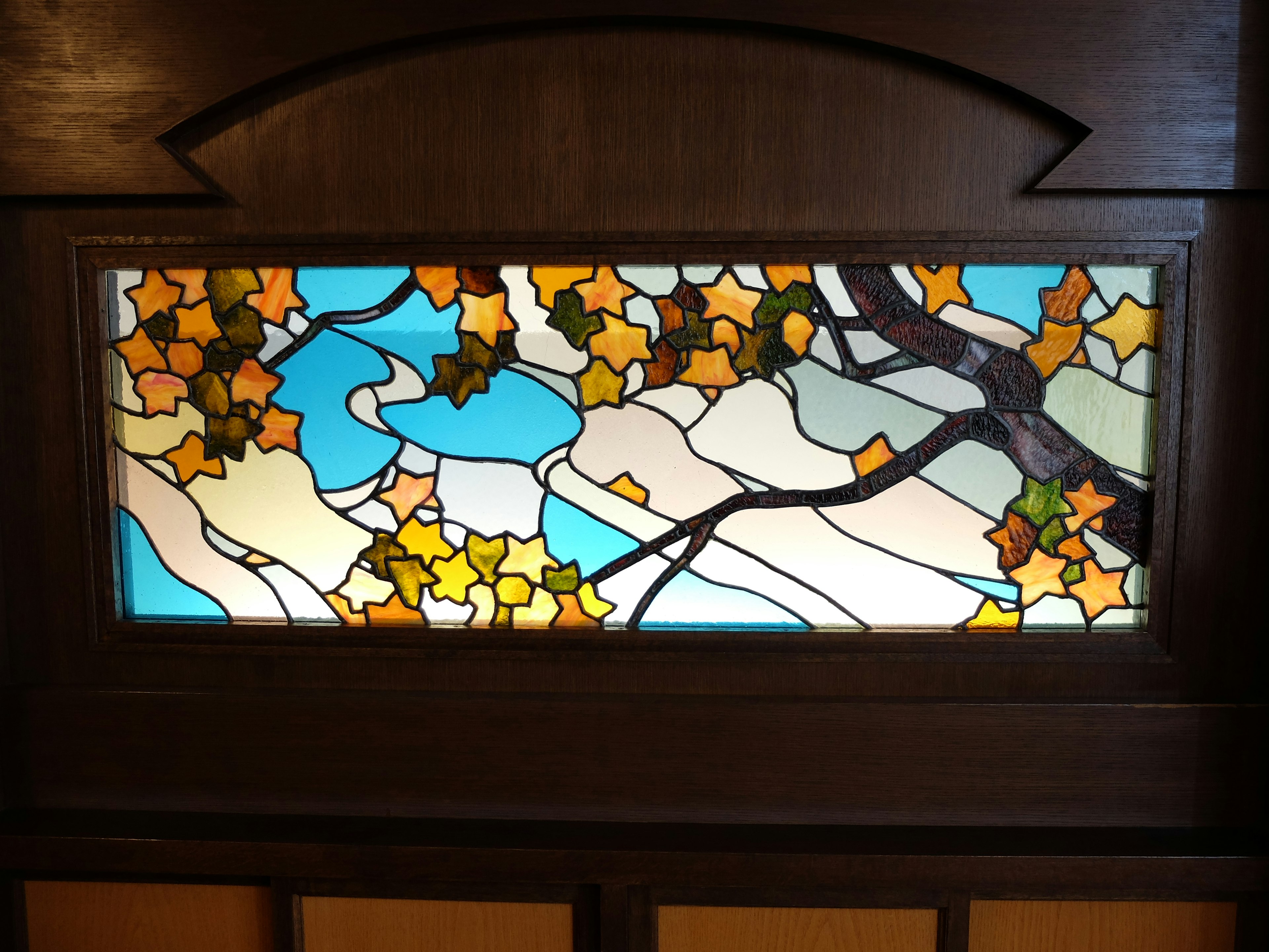 Beautiful stained glass window featuring autumn leaves