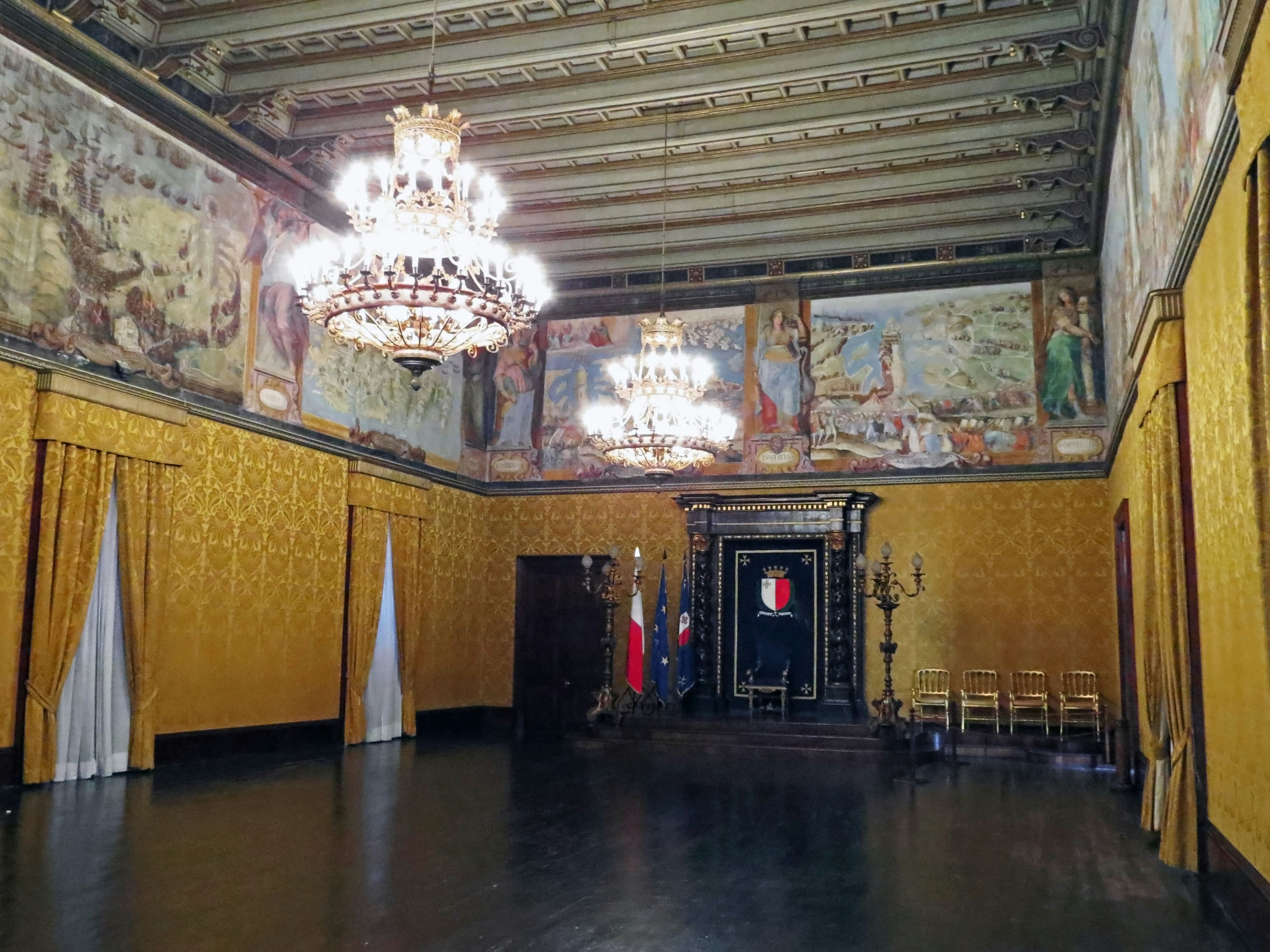 Habitación espaciosa con candelabros lujosos y cortinas doradas Murales hermosos decoran las paredes