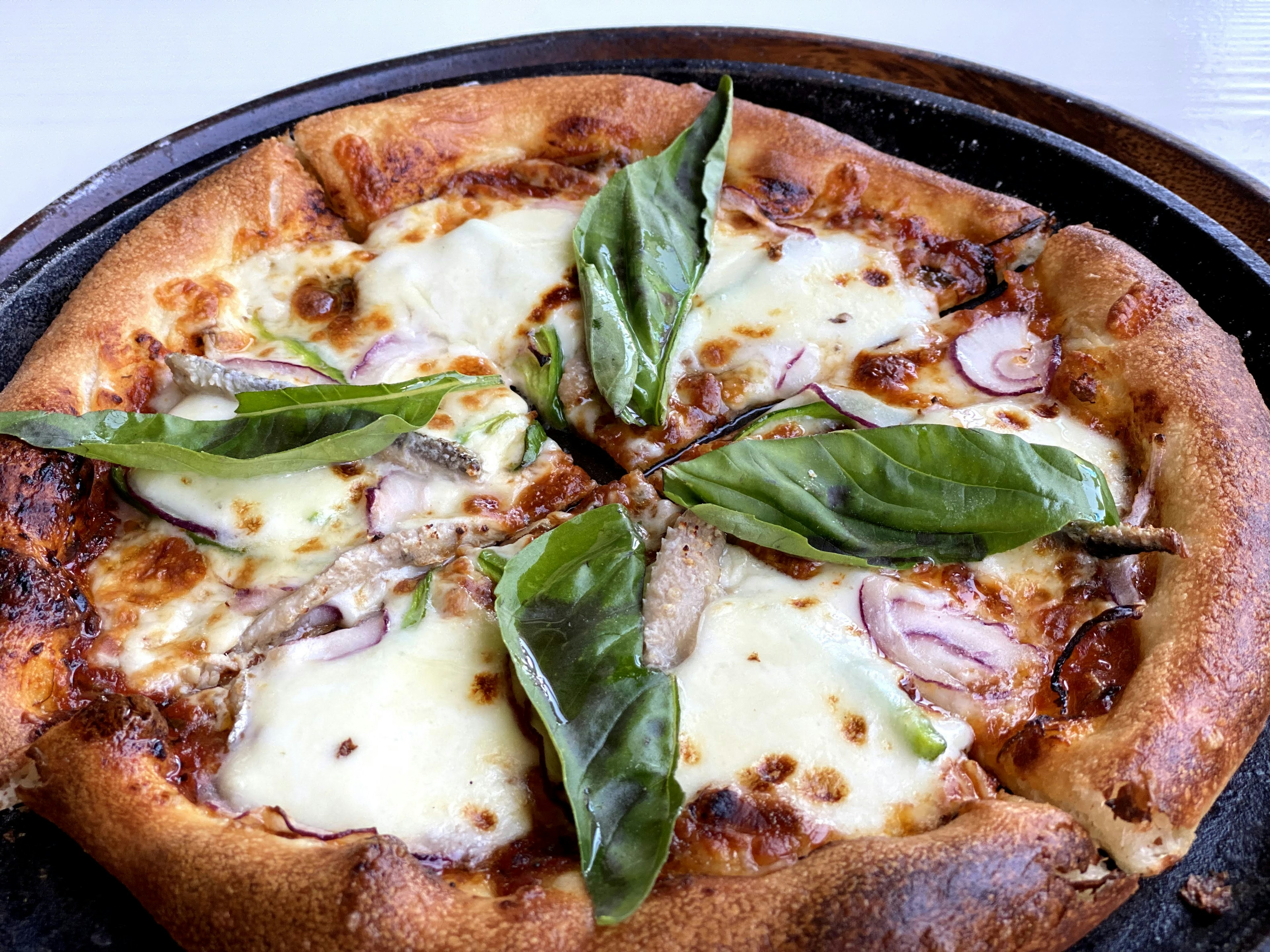 Pizza phủ húng quế và phô mai trên vỏ giòn