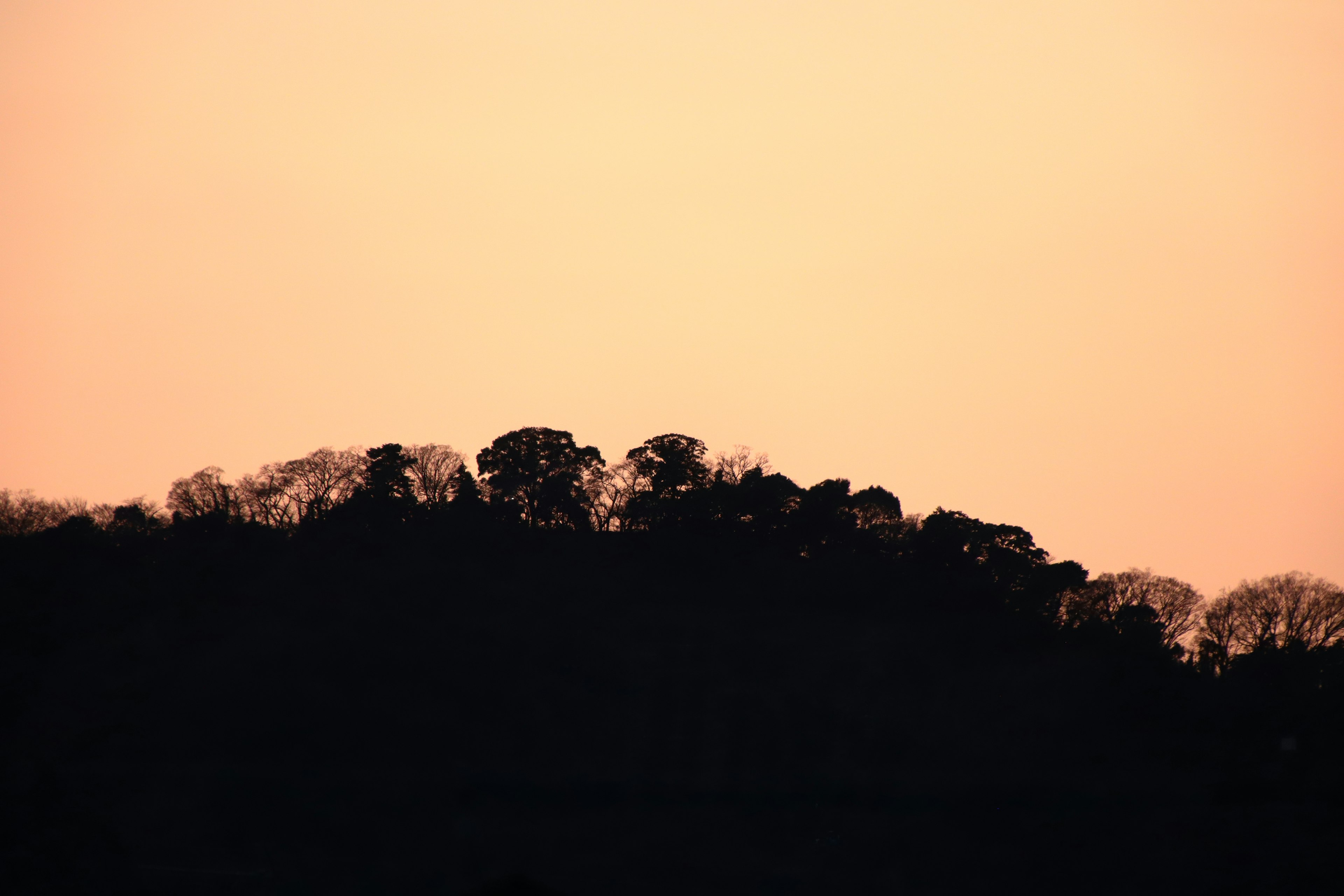 Silhouette eines Hügels vor einem Sonnenuntergangshimmel