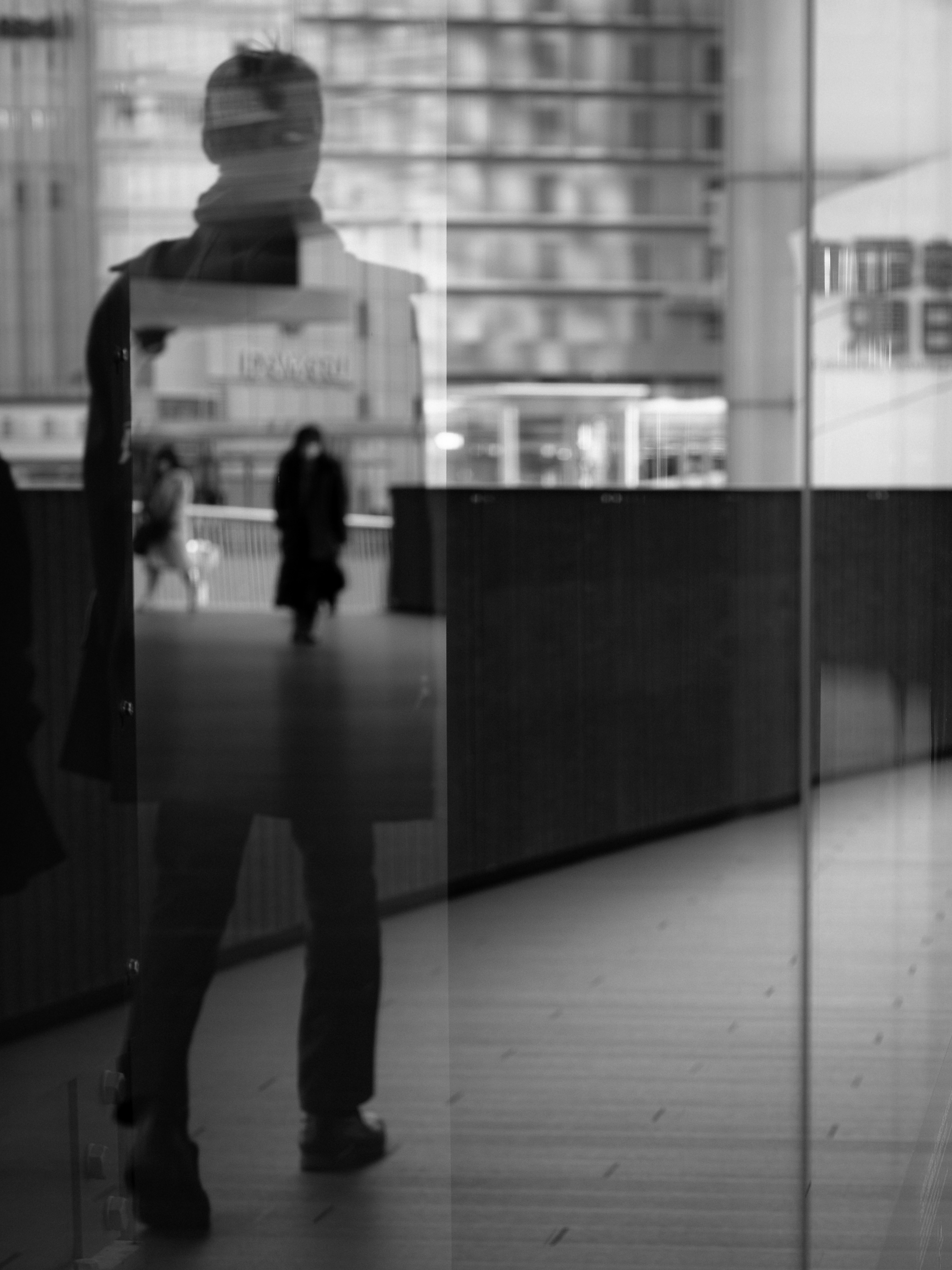 Silhouette of a person reflected in glass with urban background