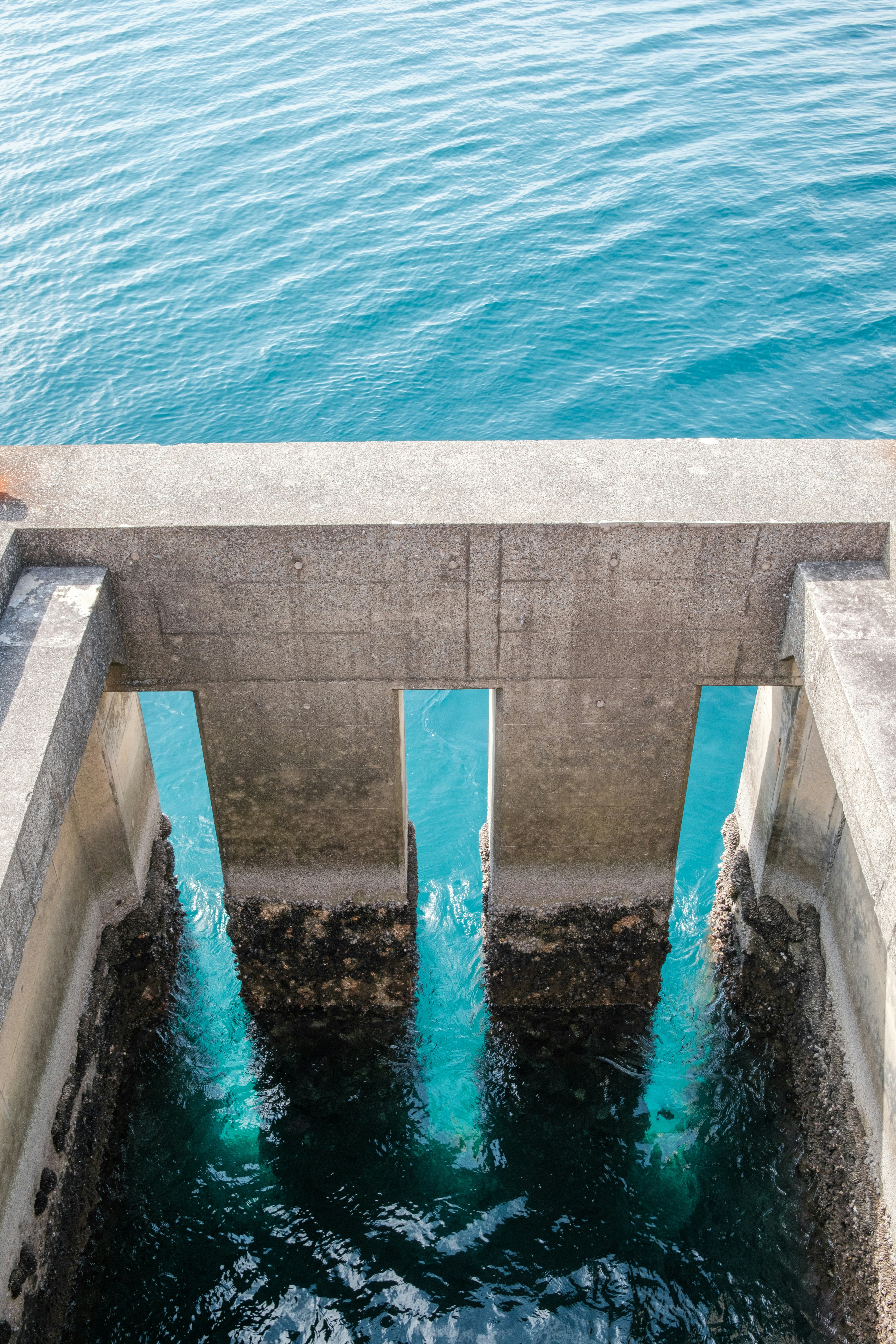 Blick von oben auf eine Betonkonstruktion mit fließendem Wasser