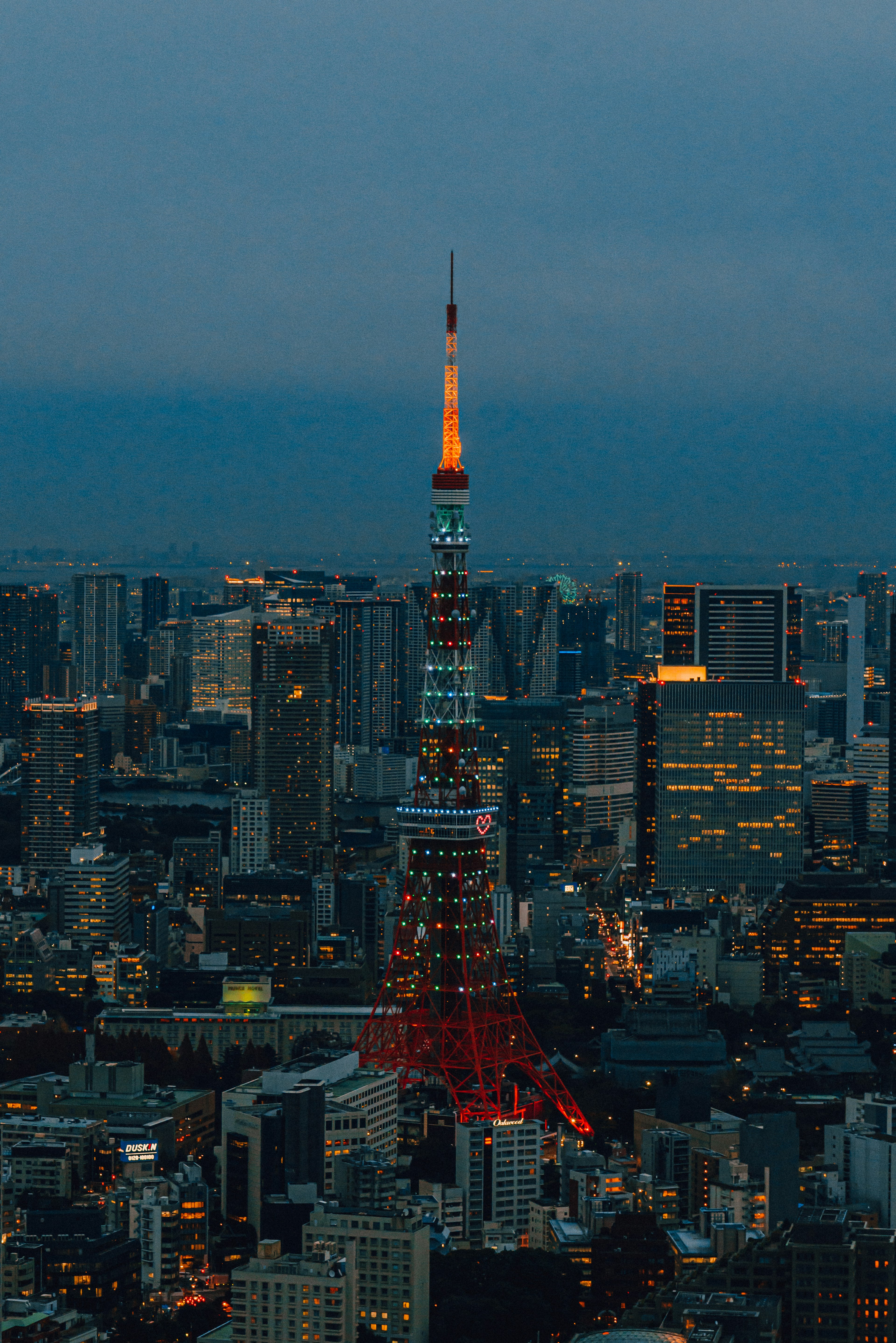 Menara Tokyo yang diterangi melawan cakrawala kota saat senja