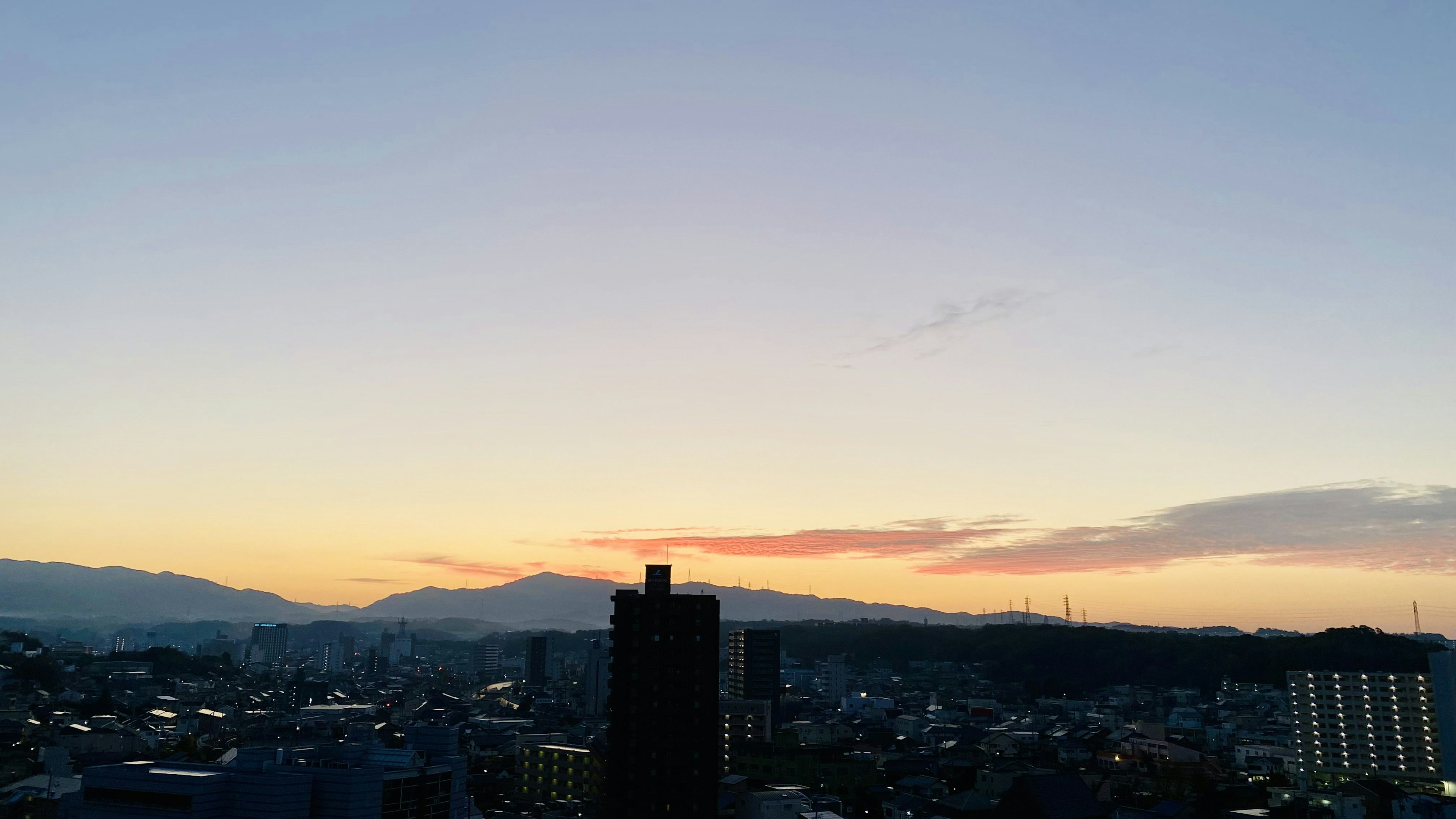 Schöne Skyline bei Sonnenuntergang mit Stadtlandschaft und Bergen