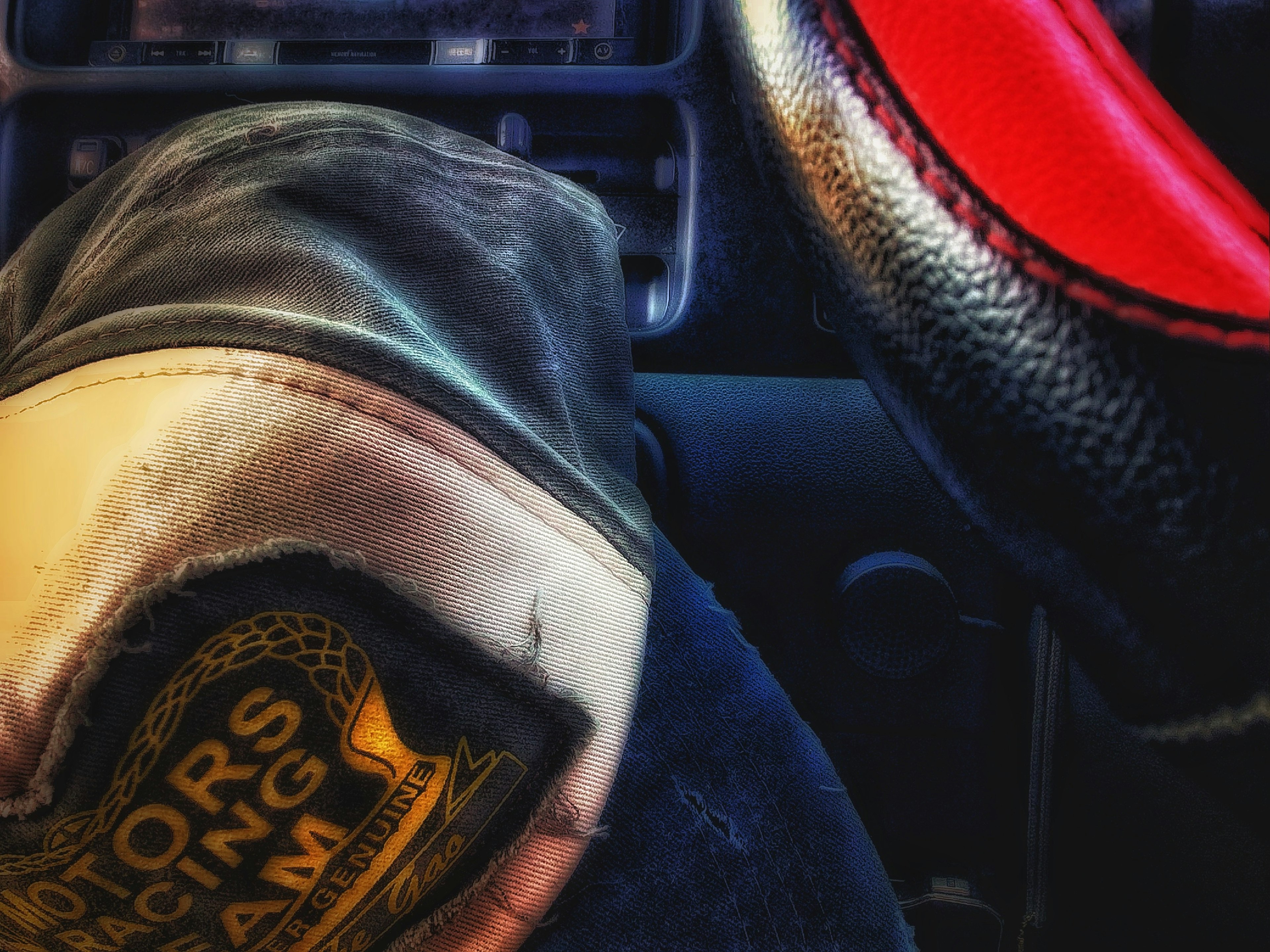 Close-up photo of a steering wheel and a glove while driving