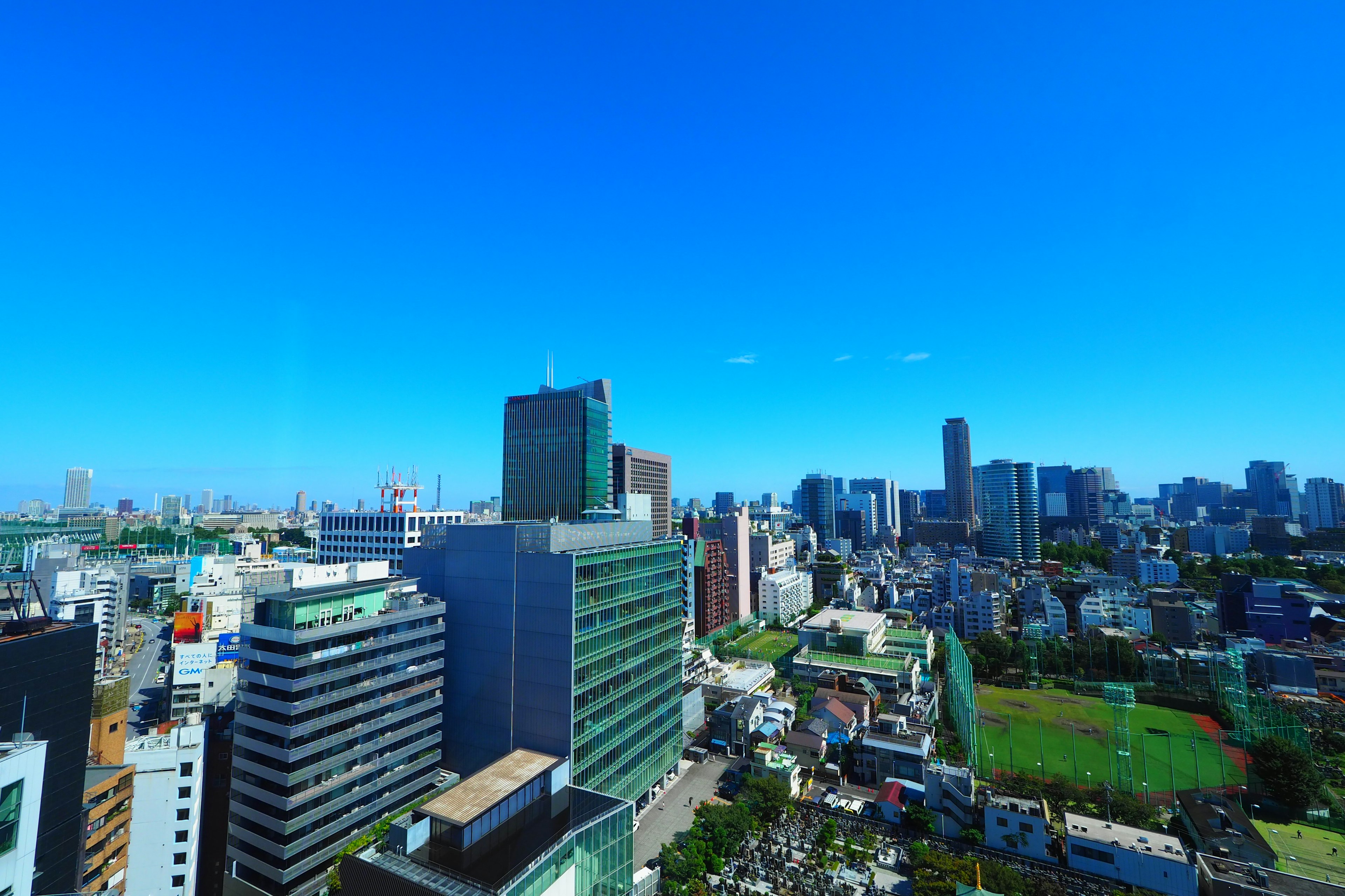 晴朗蓝天下的城市风景，高楼大厦和绿色公园