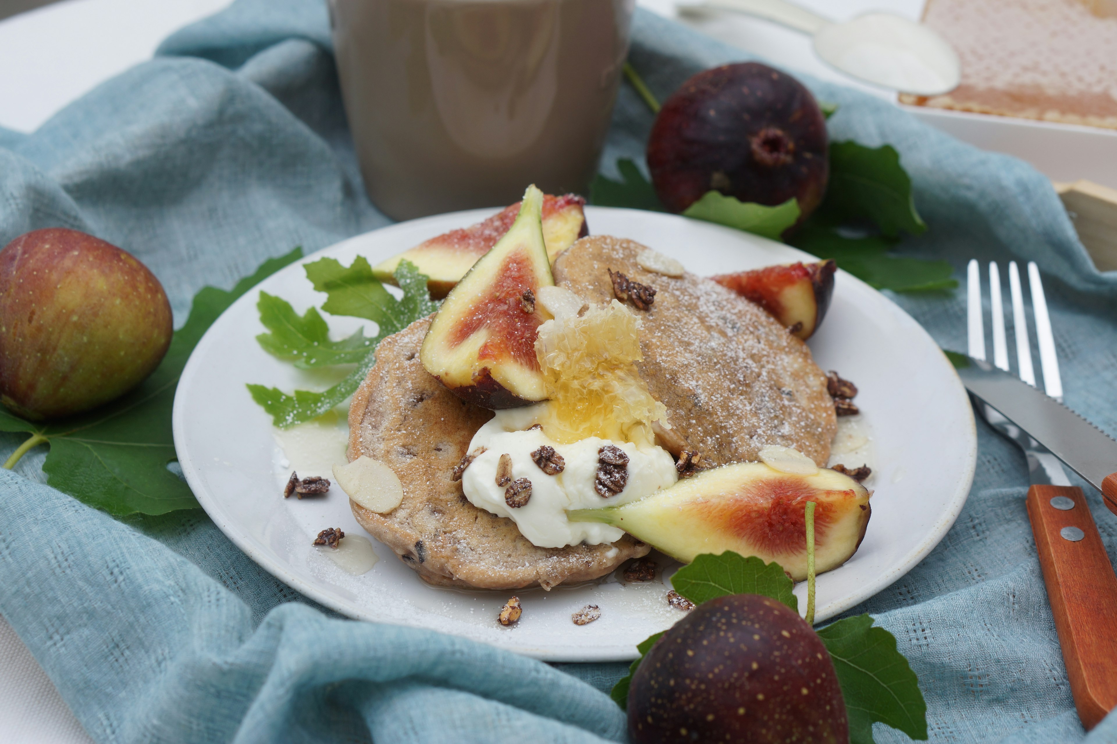 Plato de desayuno con panqueques cubiertos de higos y crema