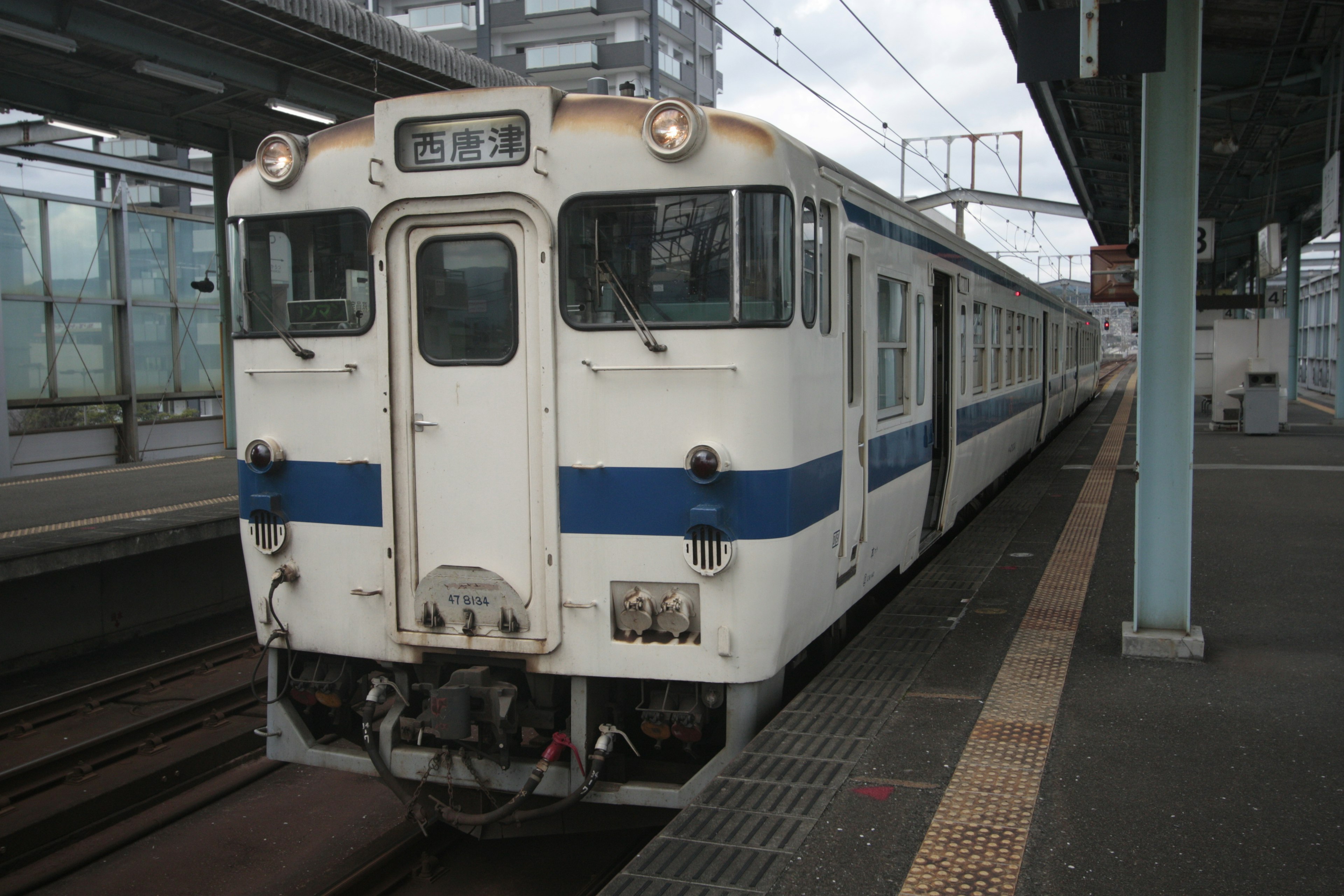 白と青のストライプの電車が駅に停車中