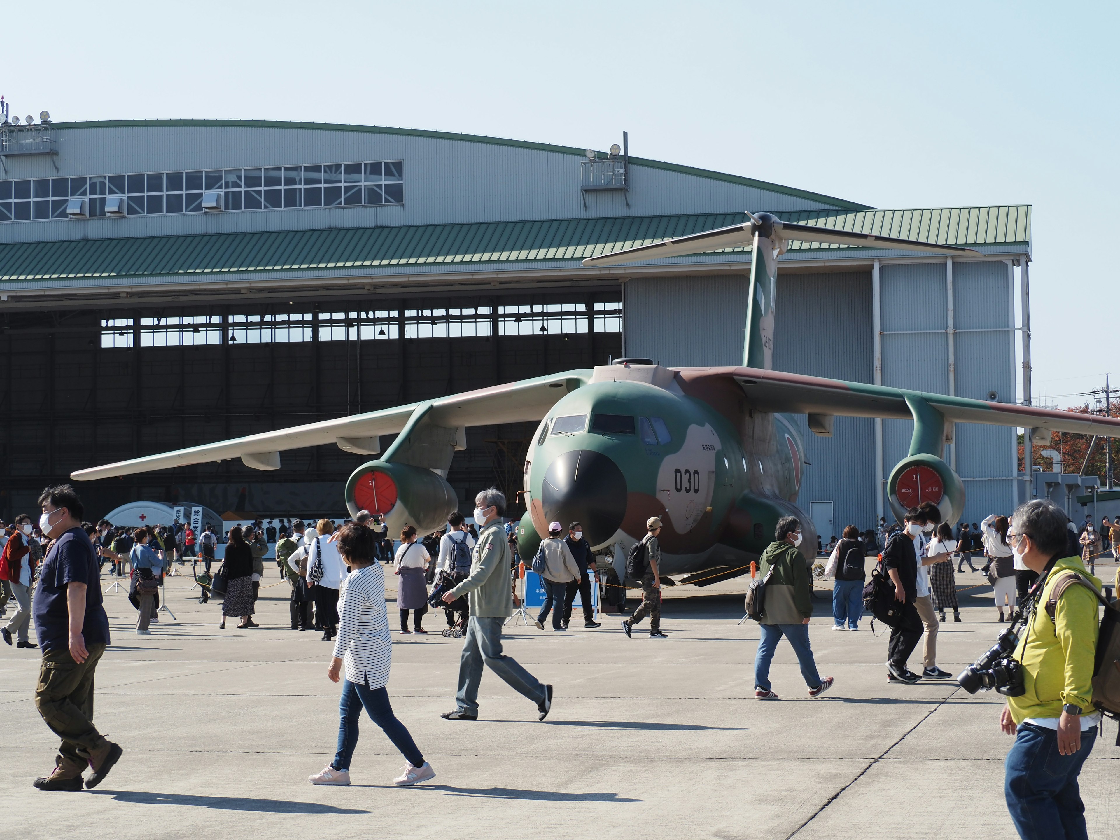 Crowd of people at an aircraft exhibition with a large military plane