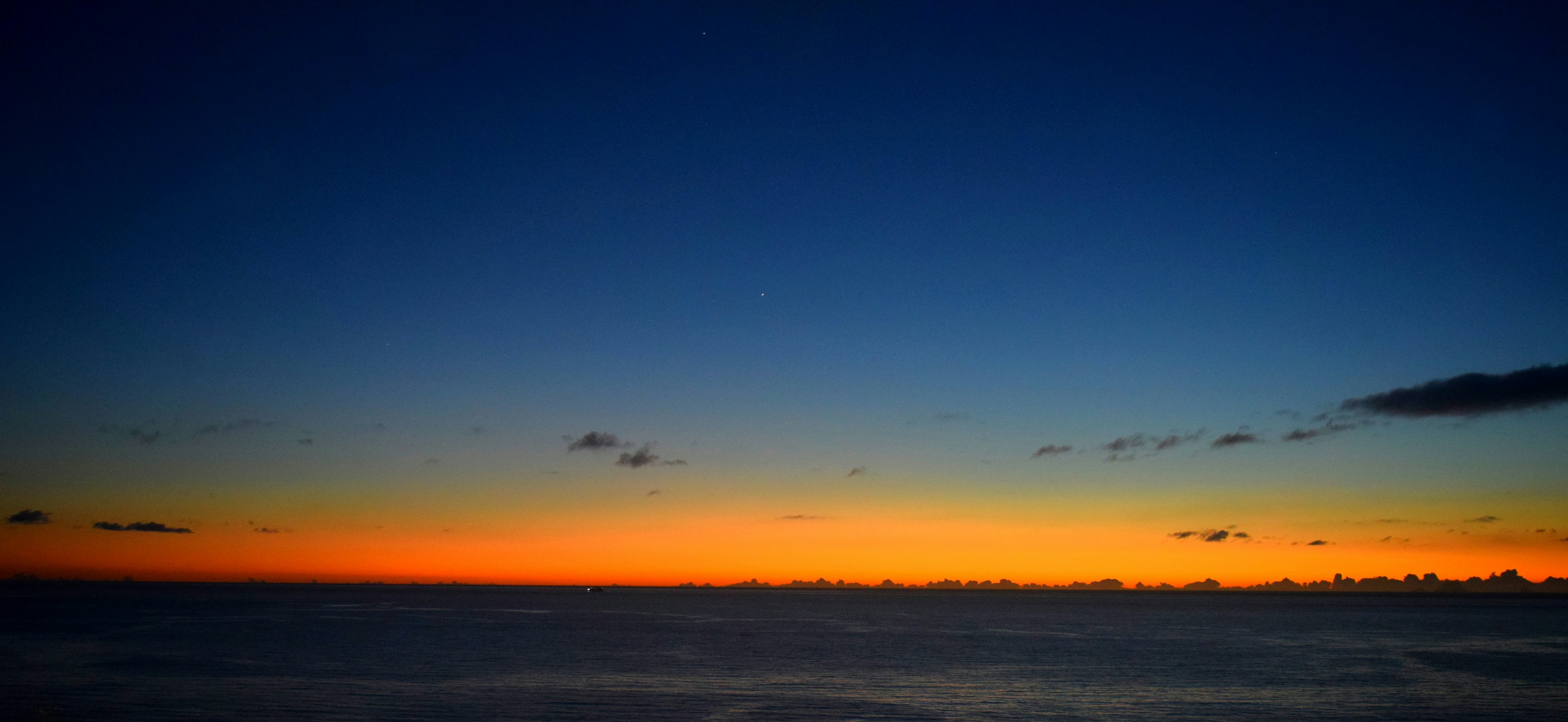 青い空とオレンジの夕焼けの水平線