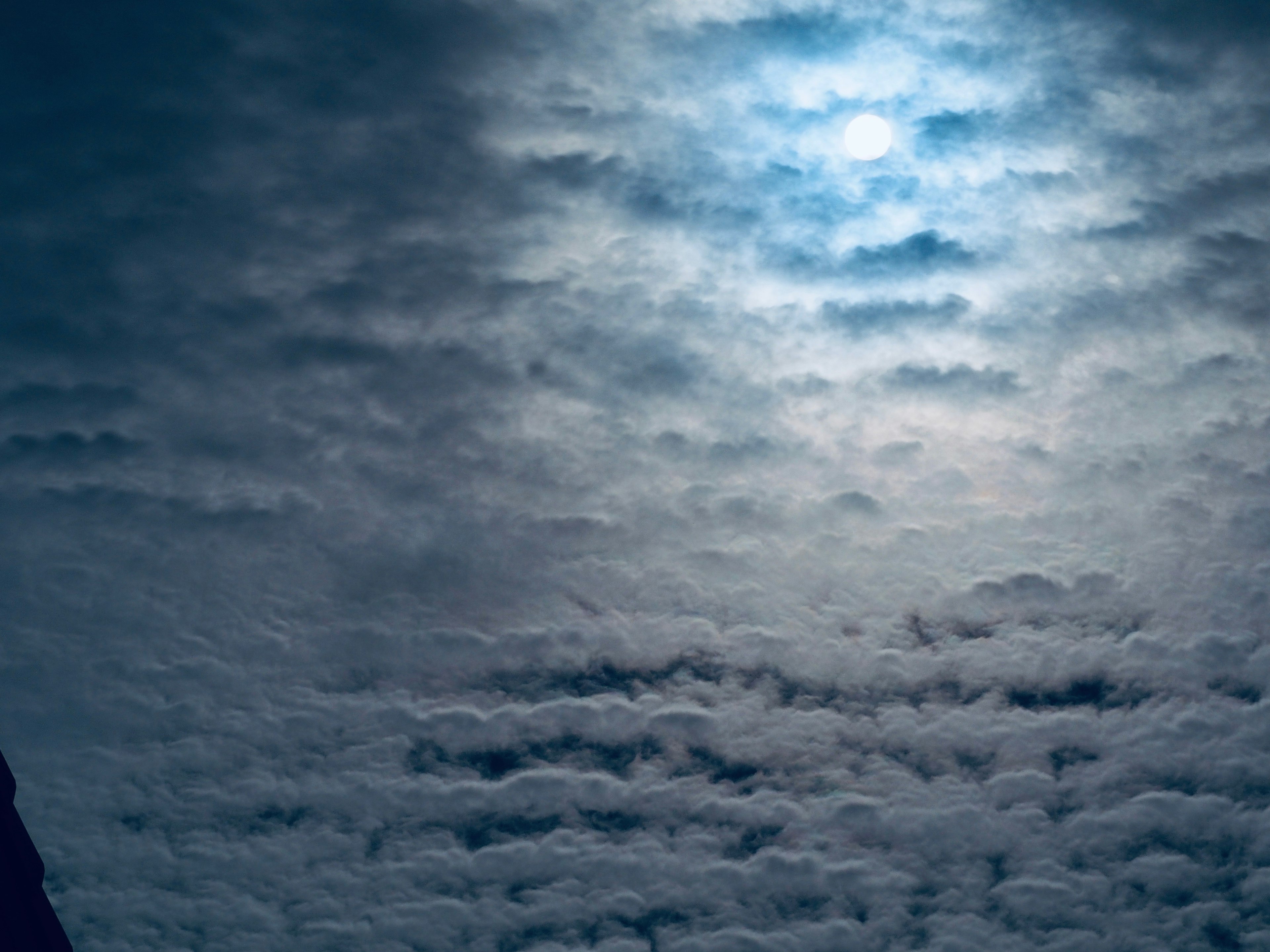 Un cielo surrealista con nubes y una luz azulada brillando