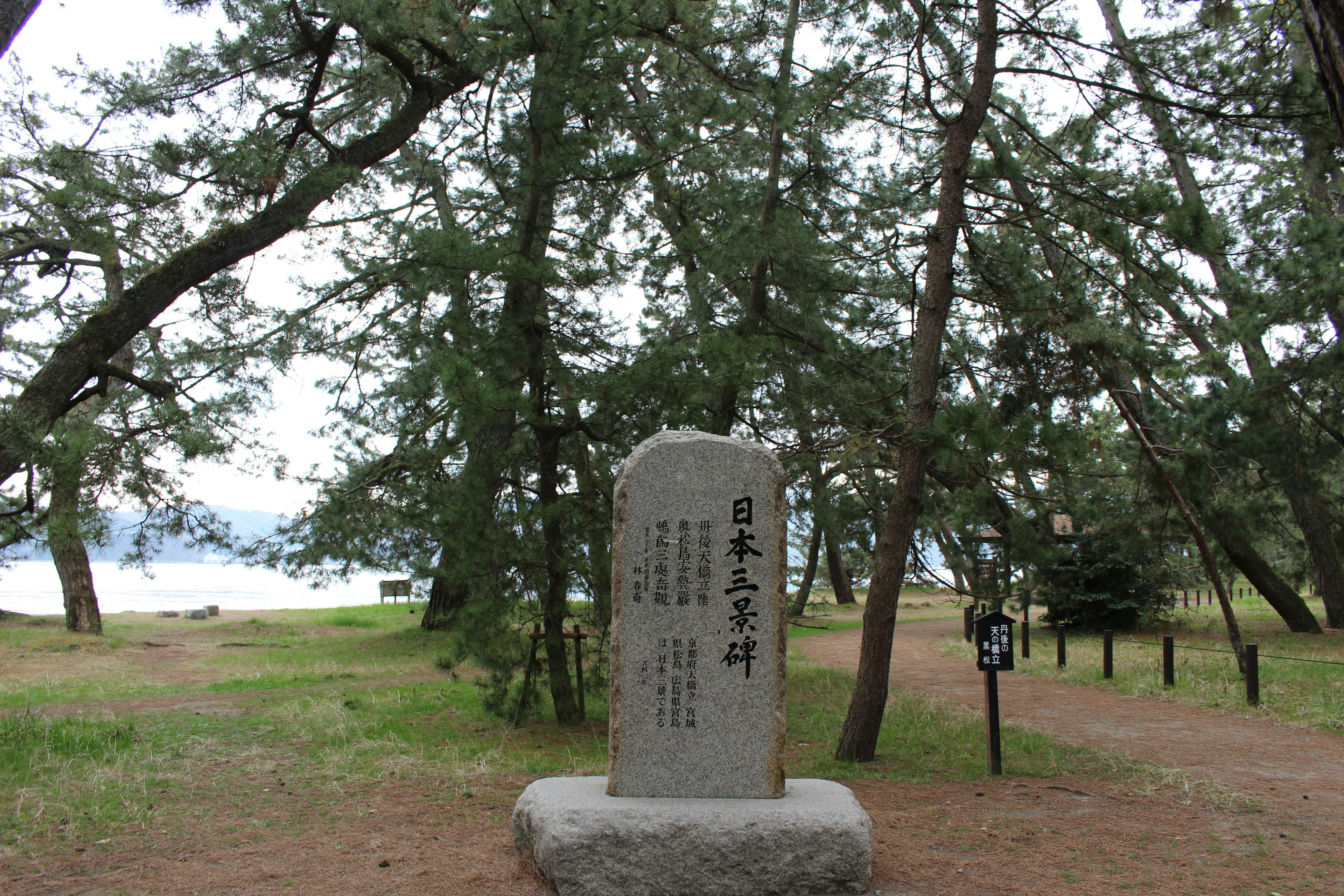 Monumento di pietra circondato da alberi verdi con vista sul lago