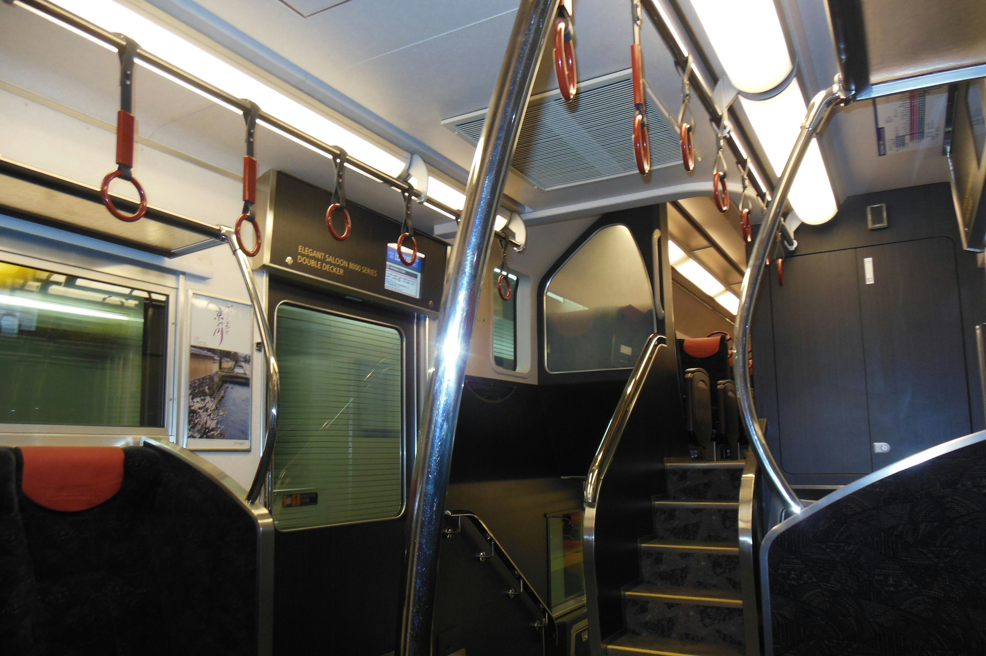 Interno di un treno con una scala e corrimano