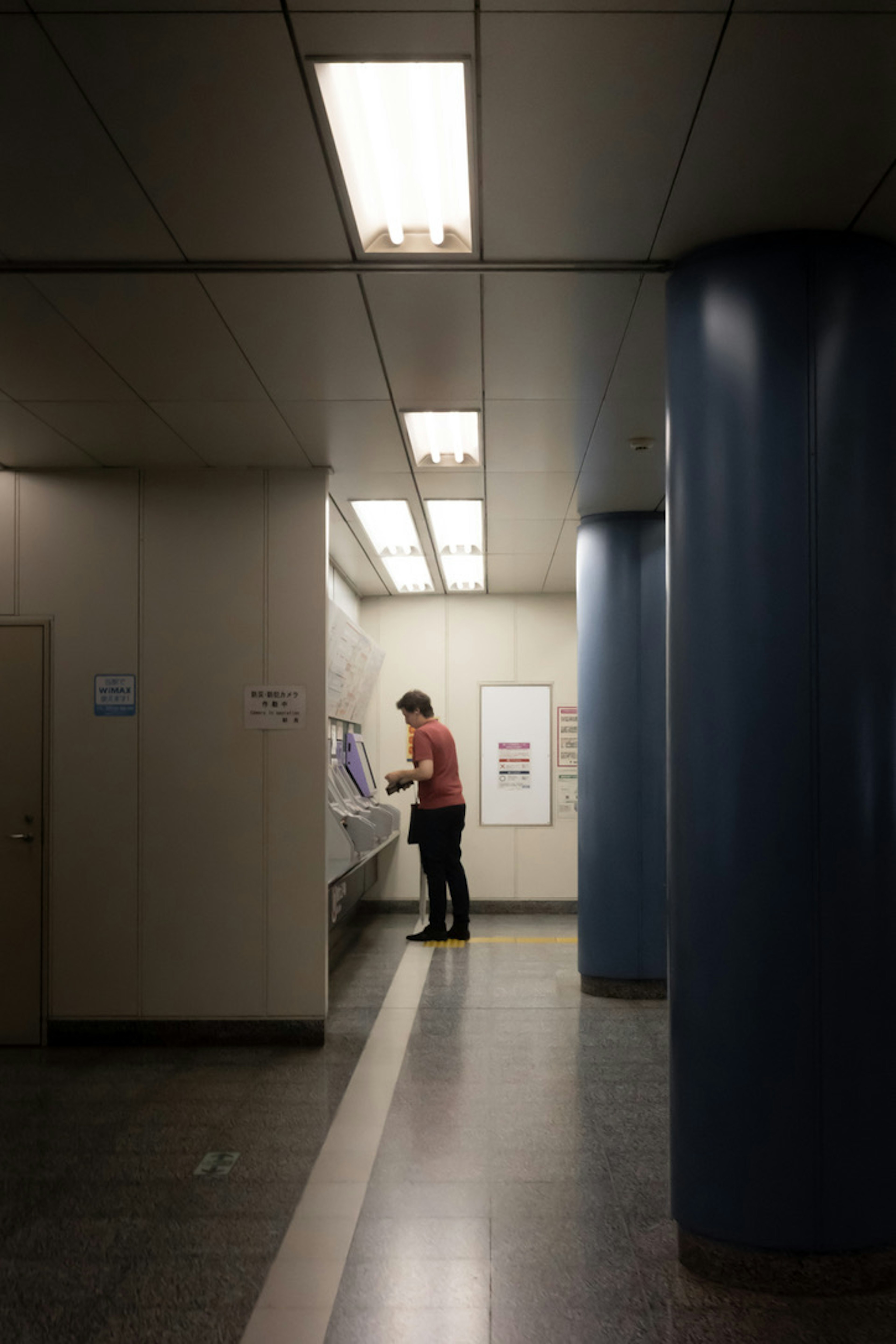 Image of a man working in a restroom featuring bright lighting and a simple interior