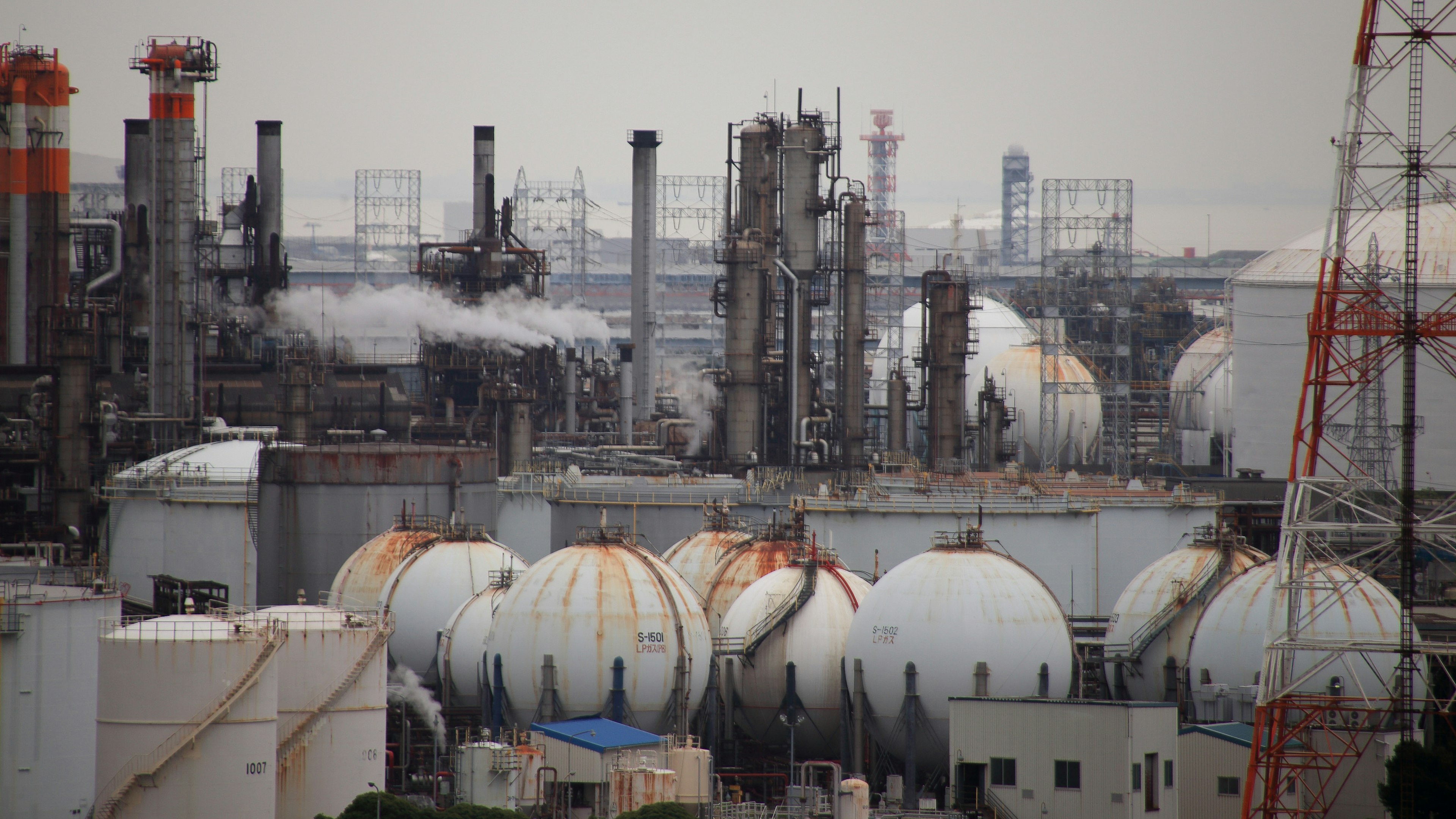 Structures complexes d'une usine industrielle avec des cheminées émettant de la fumée