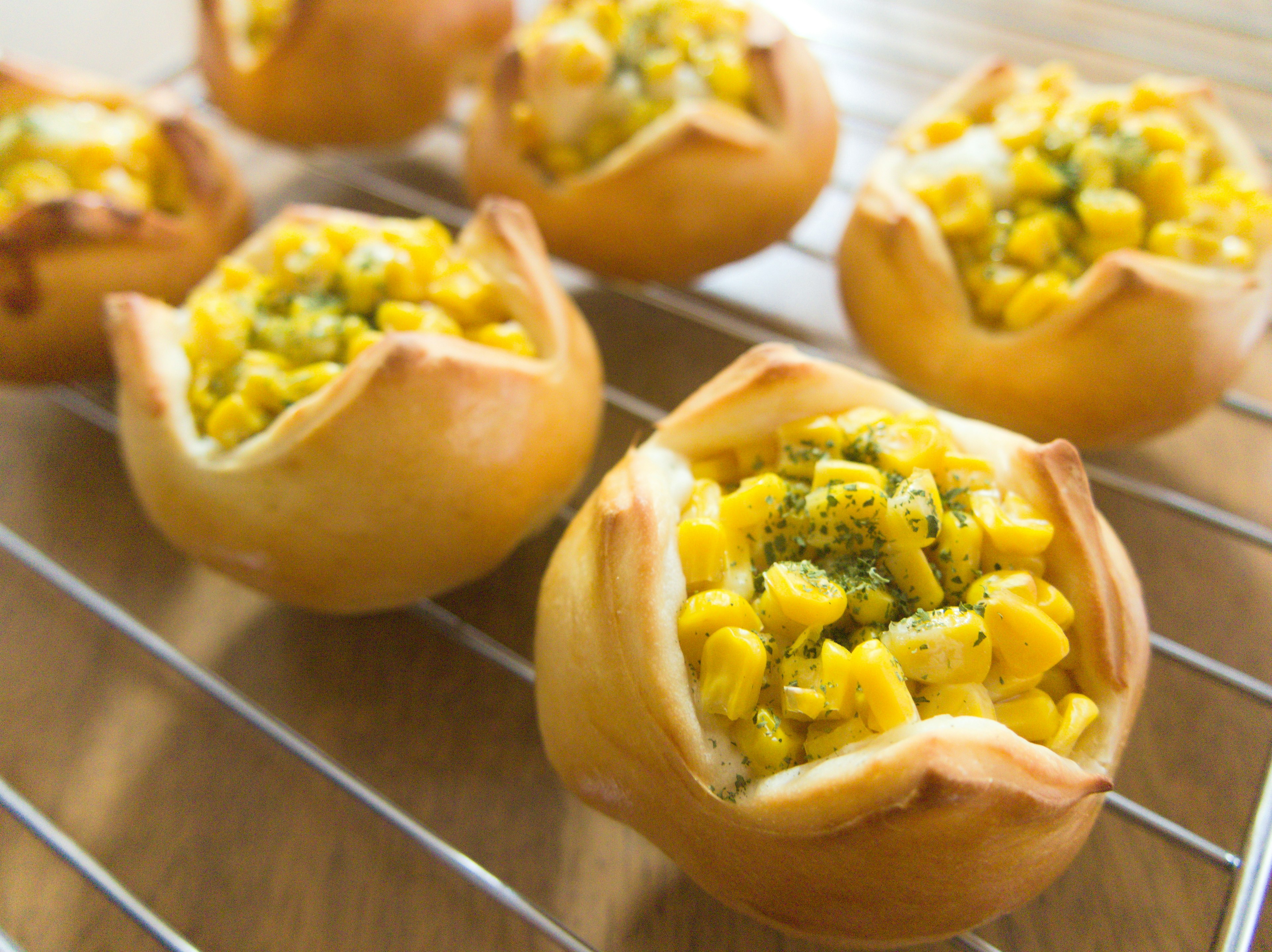 Freshly baked corn tarts arranged on a cooling rack